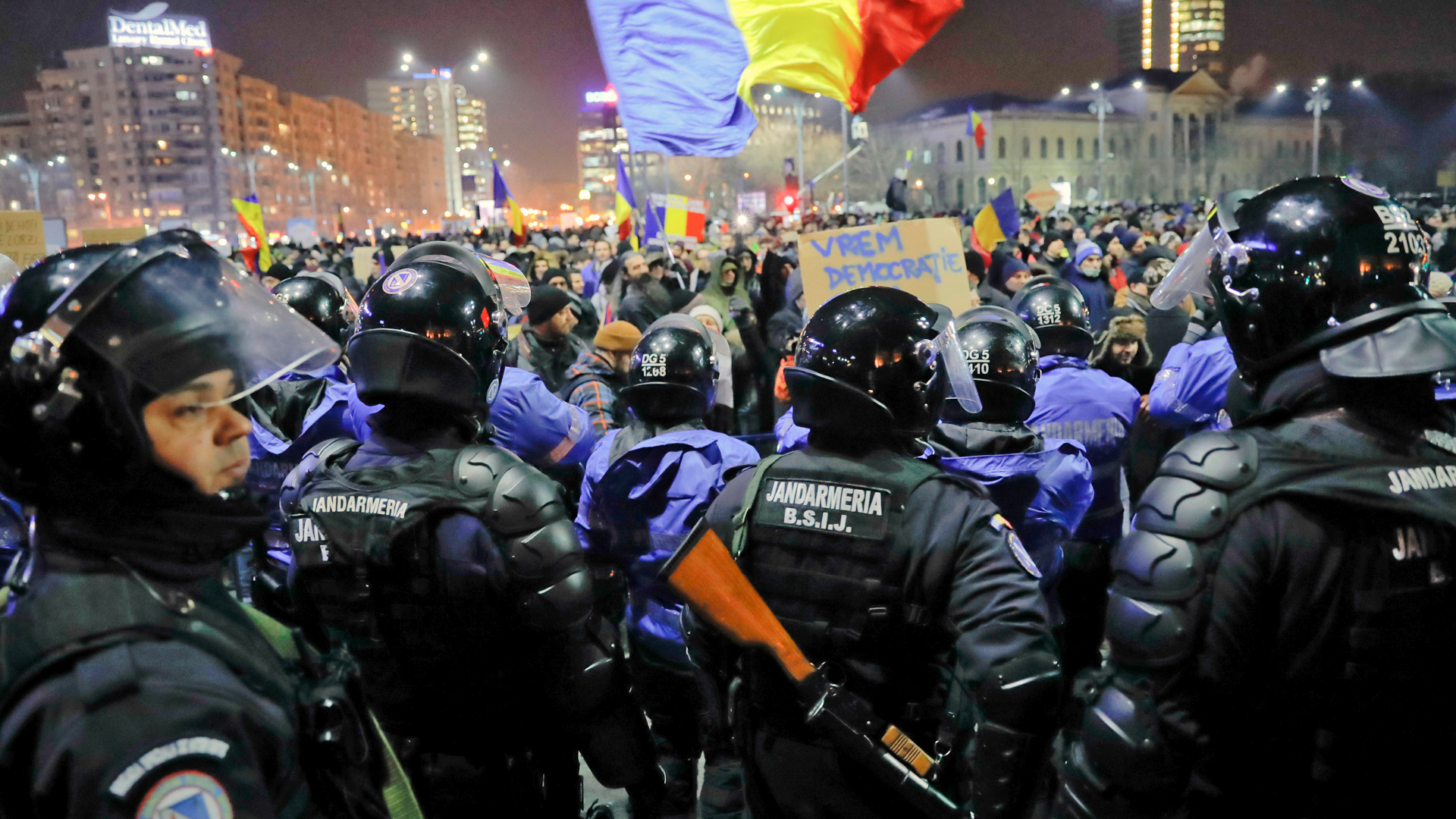 Polizisten schirmen das Regierungsgebäude in Bukarest vor den Demonstranten ab. | AP