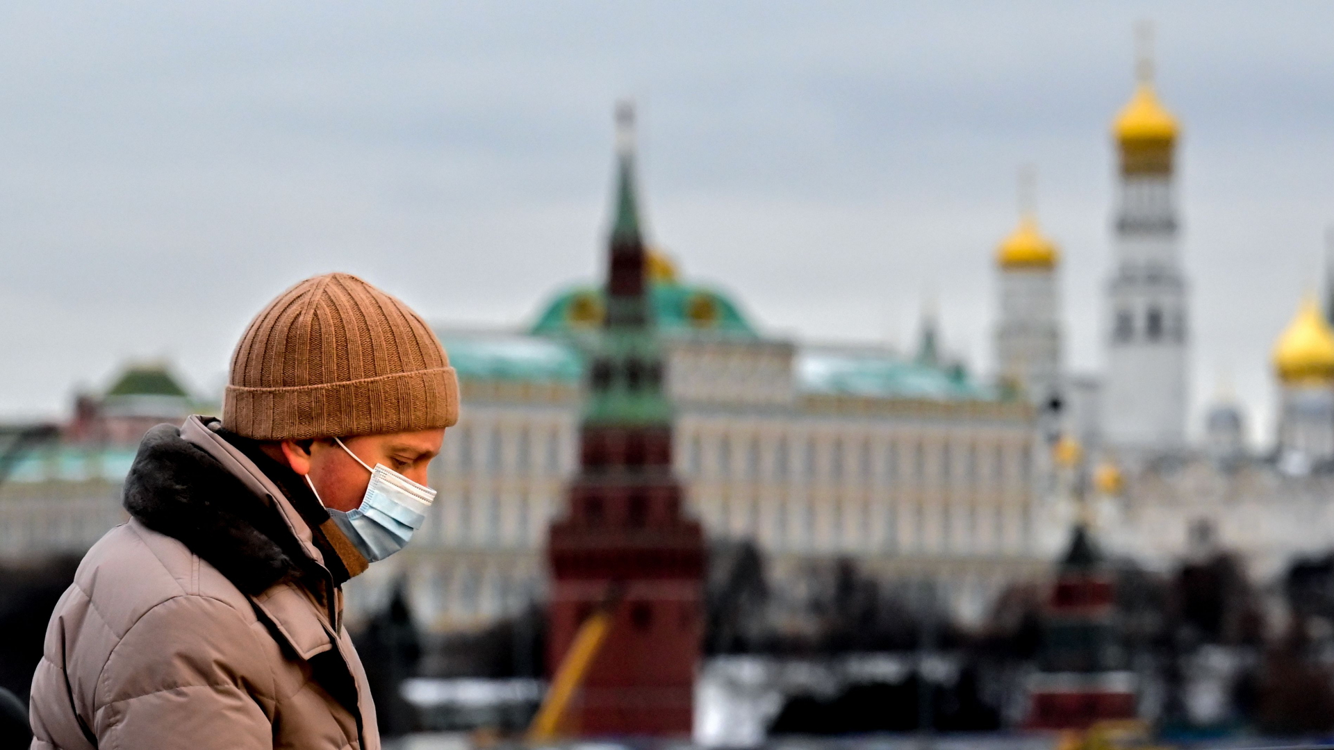 Mann mit Maske vor dem Kreml
