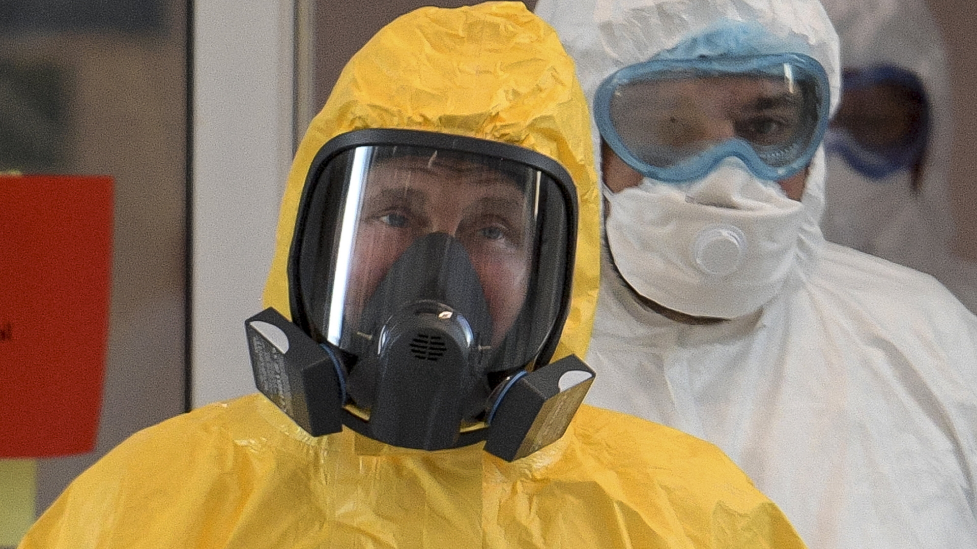 Der russische Präsident Wladimir Putin trägt einen gelben Schutzanzug, um sich in einer Klinik über die Lage in der Coronakrise zu informieren. | AP