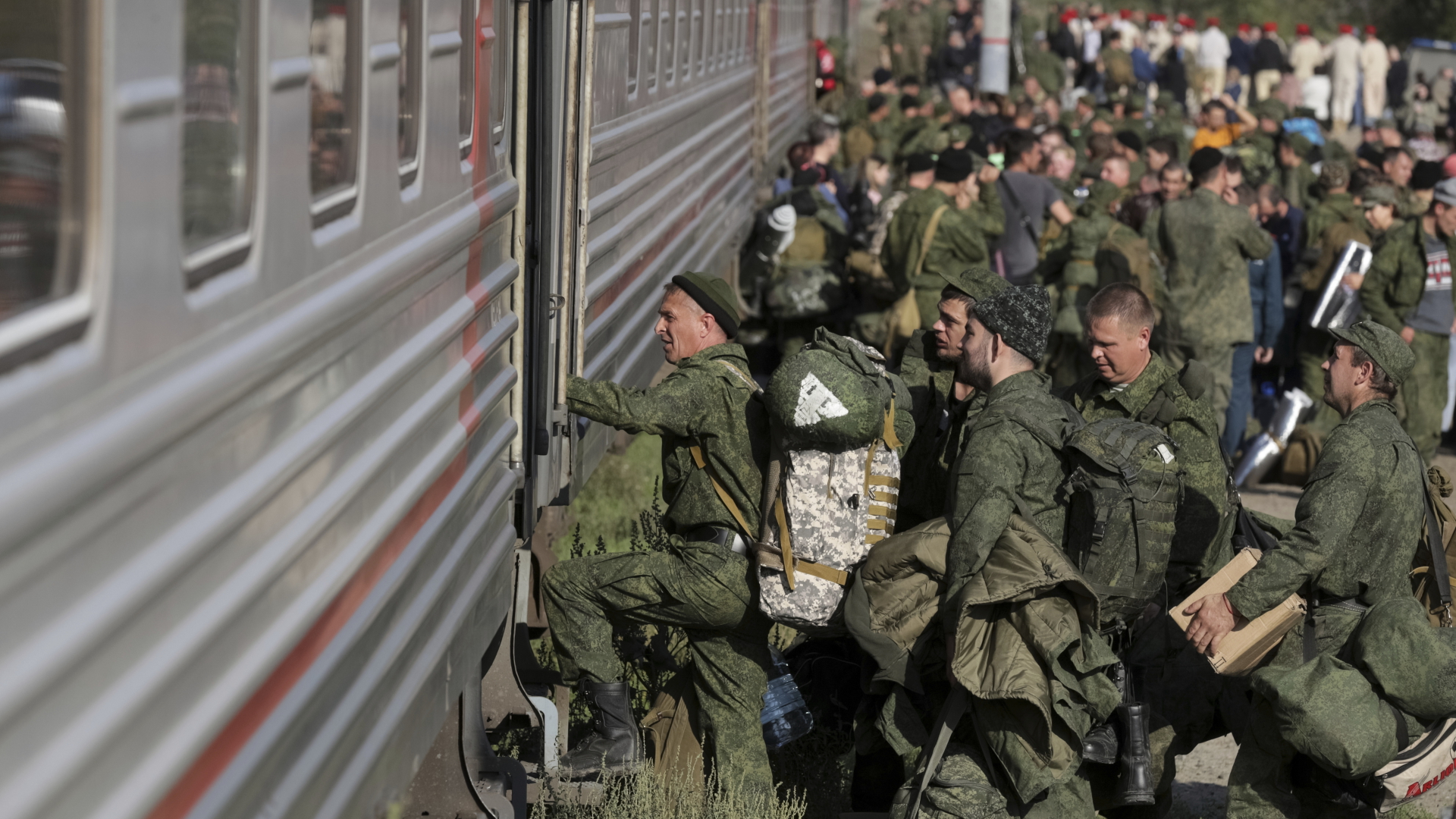 Zum Militärdienst einberufene Männer steigen in einen Zug