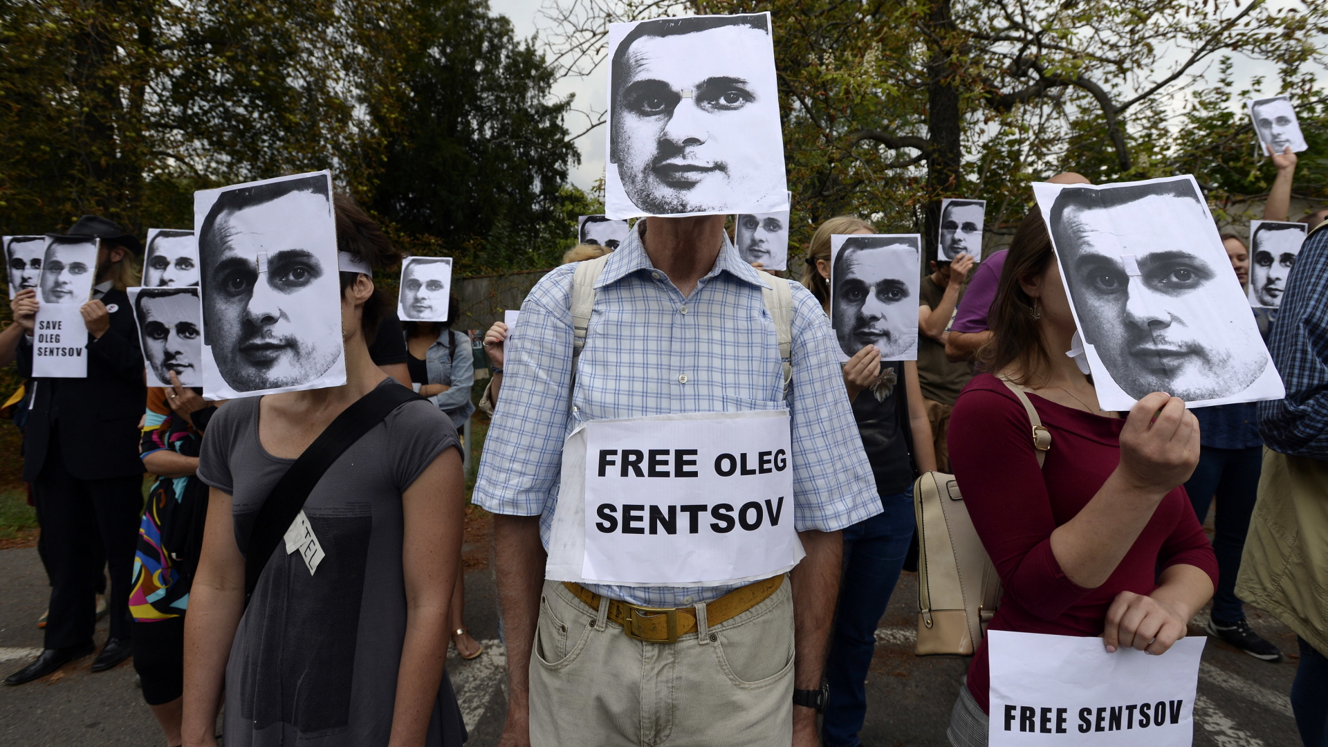 Protest für Sensow: Demonstranten tragen Masken des ukrainischen Regisseurs und fordern dessen Freilassung. | Bildquelle: dpa
