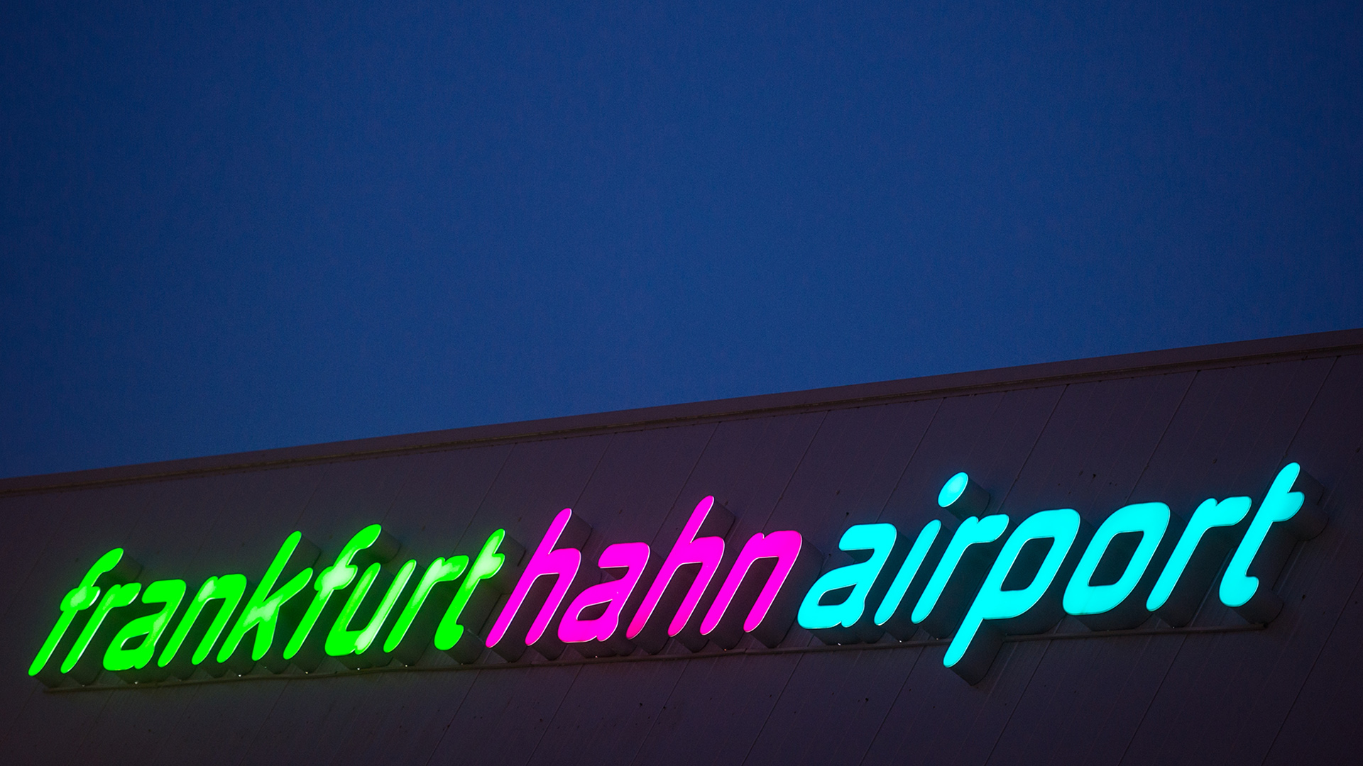 Der Schriftzug "frankfurt hahn airport" leuchtet auf einem Flughafengebäude. | dpa