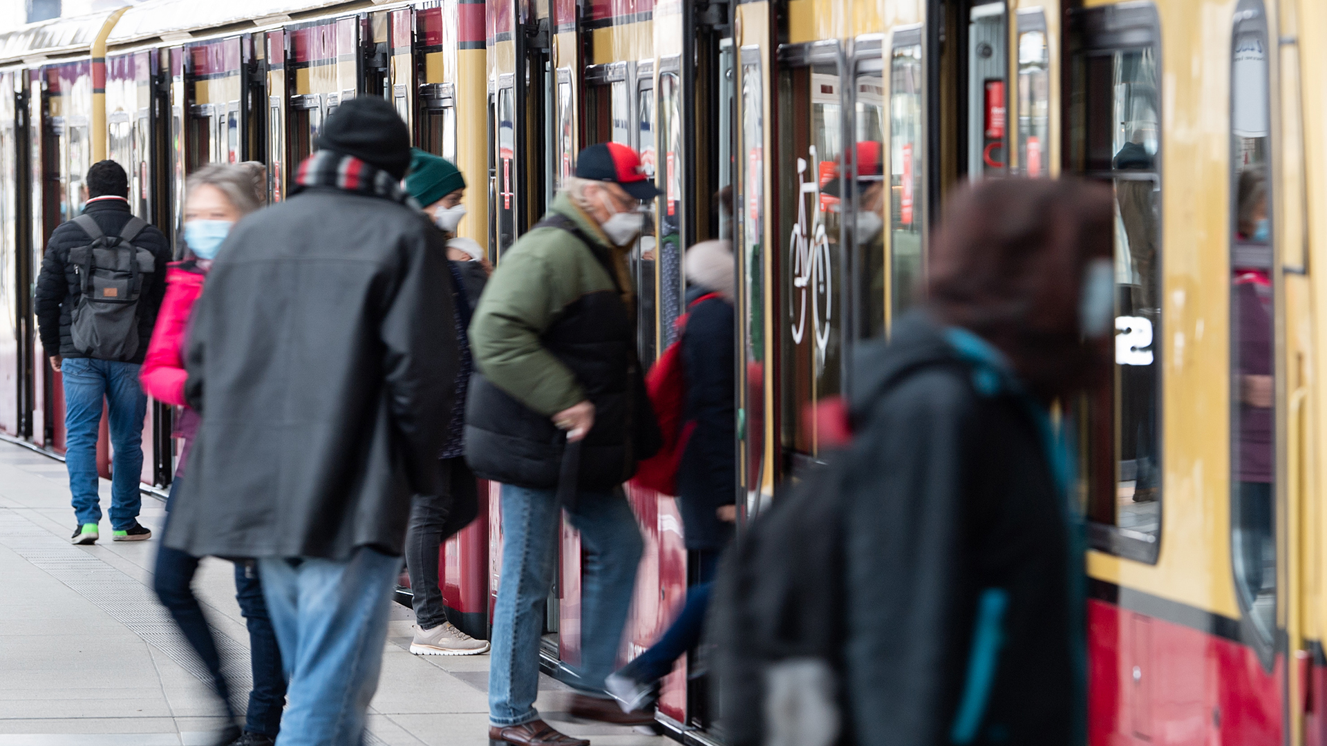 Fahrgäste mit Mund-Nasen-Bedeckungen steigen am Bahnhof Friedrichstraße in Mitte in eine S-Bahn. | dpa