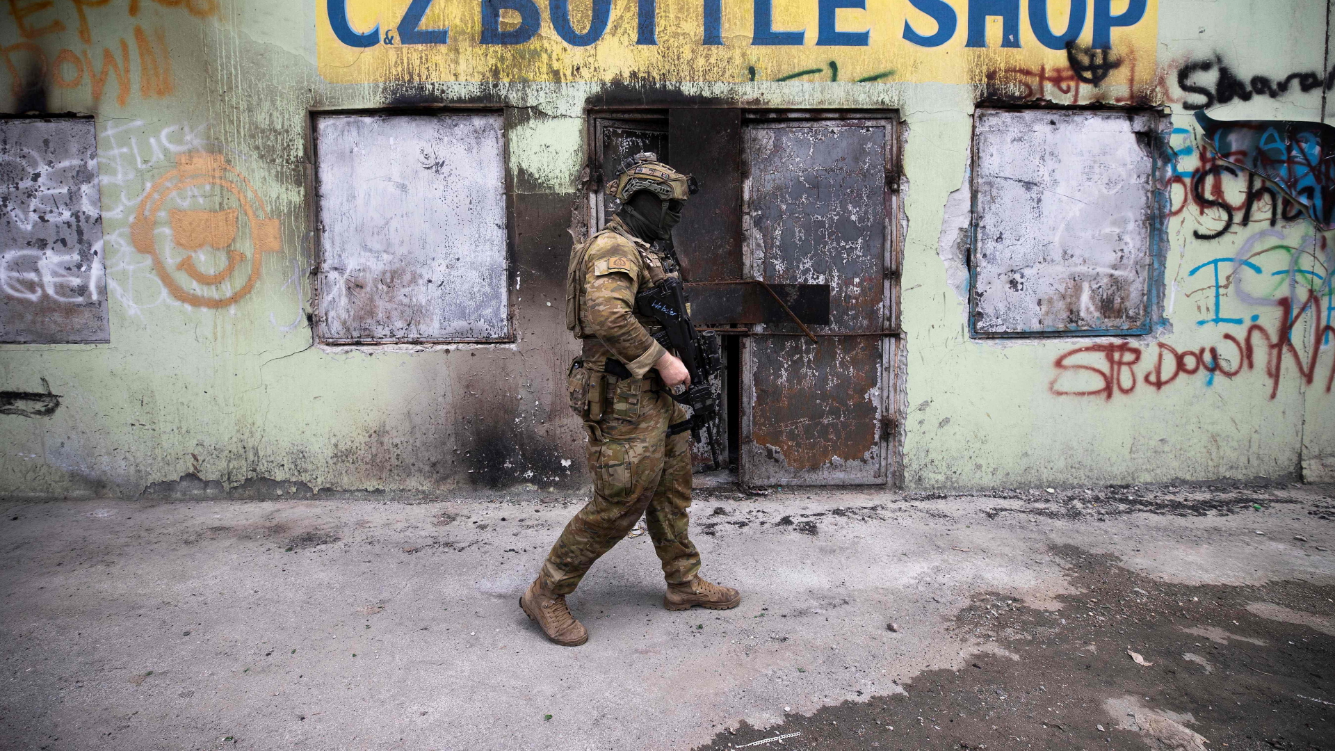 Ein australischer Soldat patrouilliert vor einem ausgebrannten  Gebäude in der Hauptstadt Honiara auf den Salomonen. | AFP