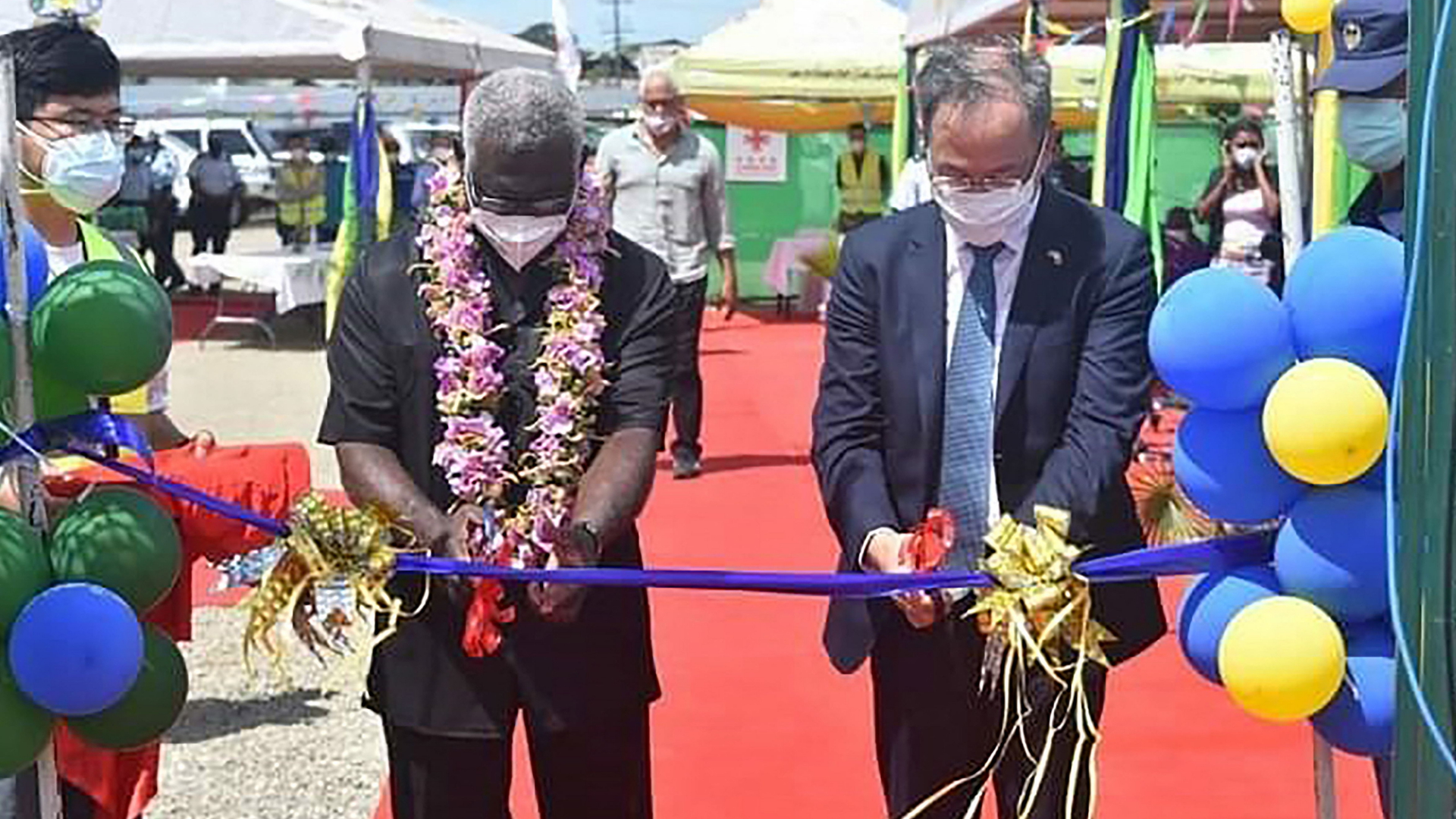 Manasseh Sogavare und der chinesische Botschafter auf den Salomonen, Li Ming, zerschneiden feierlich ein Band. | AFP