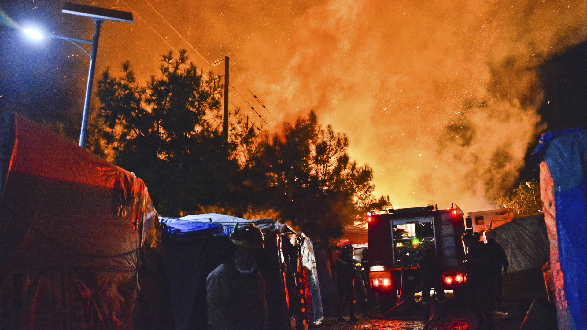 Feuerwehrleute versuchen einen Brand in einem Lager für Flüchtlinge zu löschen | dpa