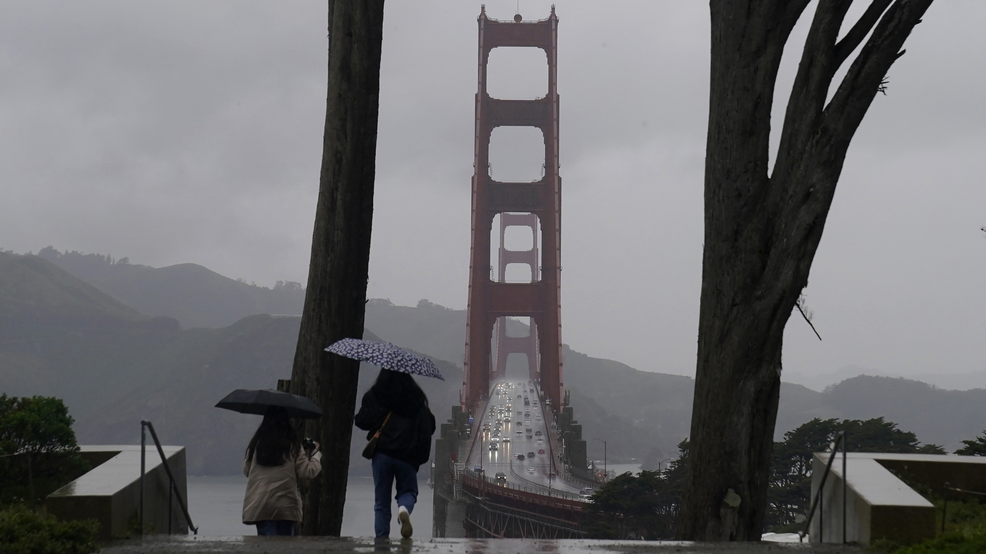 Passanten mit Regenschirm gehen an der Golden Gate Bridge in San Francisco entlang. | dpa
