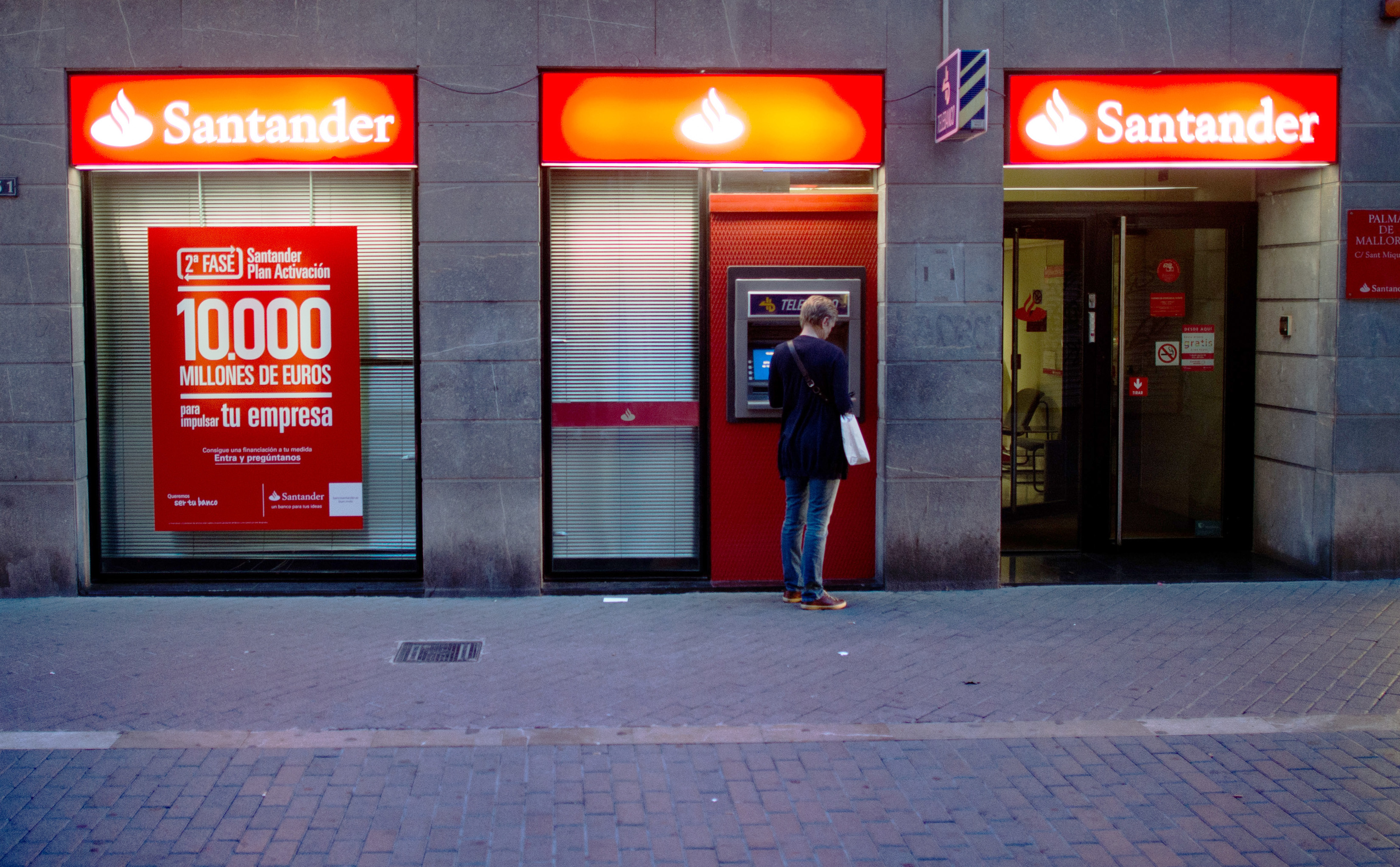 Eine Kundin steht an einem Geldautomaten einer Filiale der spanischen Bank Santander. | picture alliance / Julian Stratenschulte/dpa