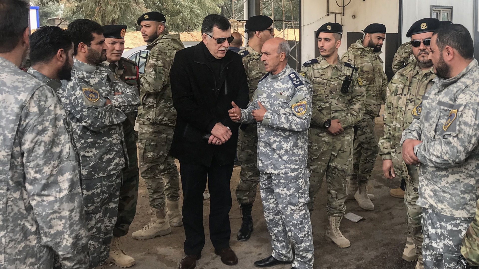 Fajes al-Sarradsch (in schwarz) bespricht sich mit Kommandeuren. | AFP