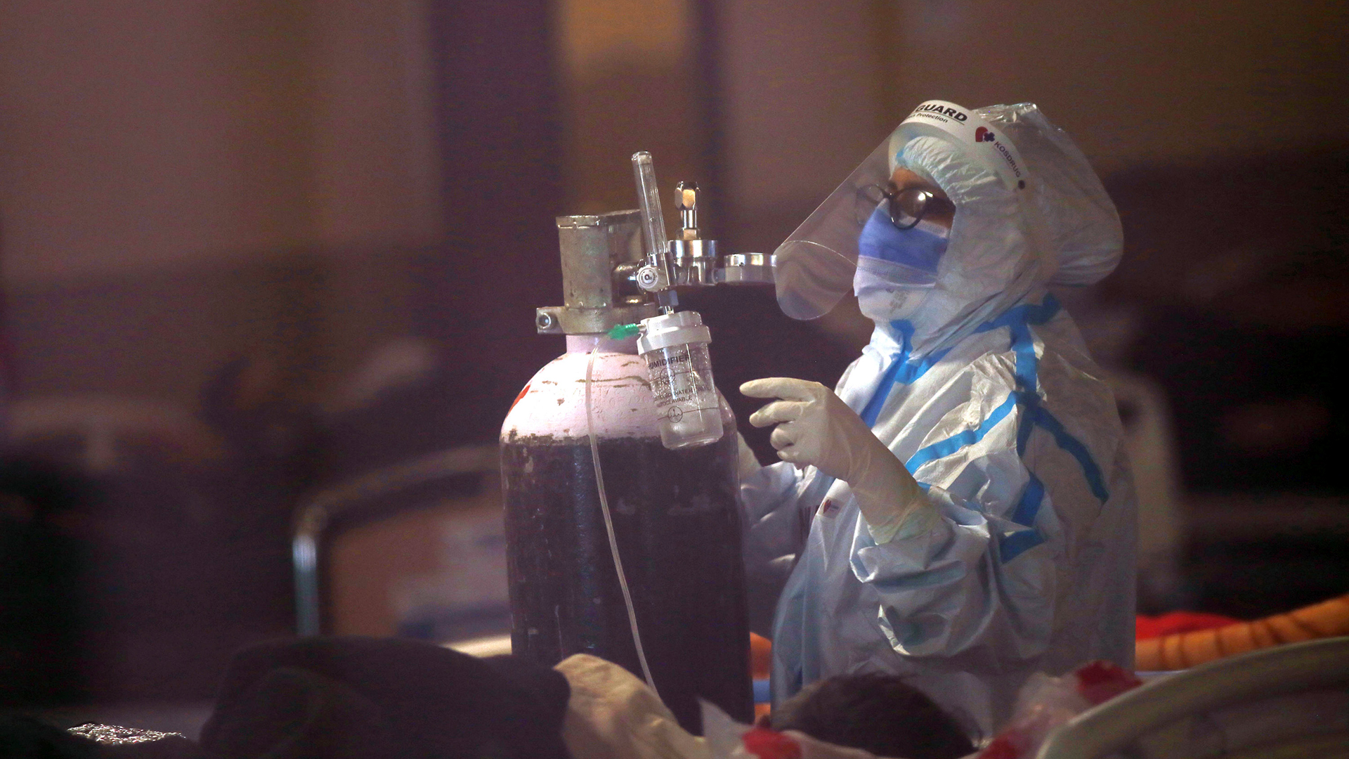 Ein medizinischer Mitarbeiter befestigt eine Sauerstoffflasche für einen COVID-19-Patienten in Neu-Delhi (Indien). | AP