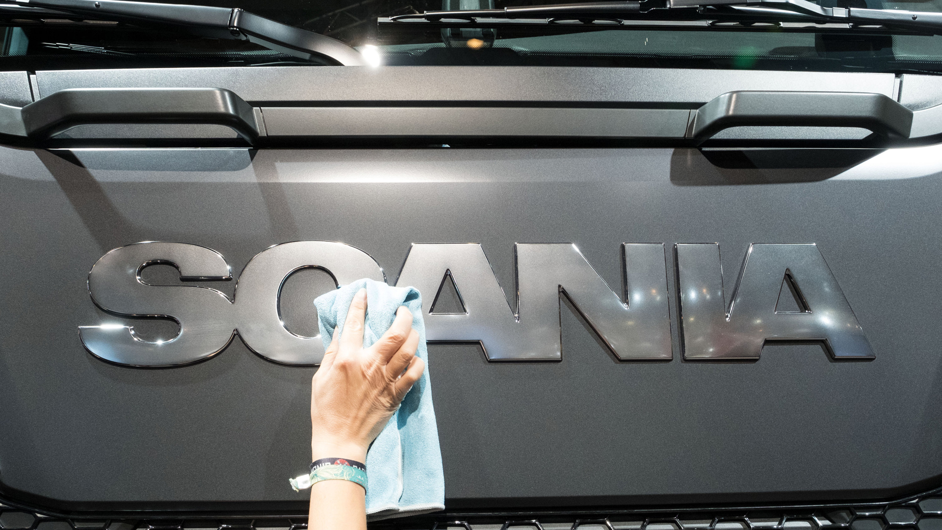Hand putzt Logo des Herstellers Scania an einem Lastwagen | dpa