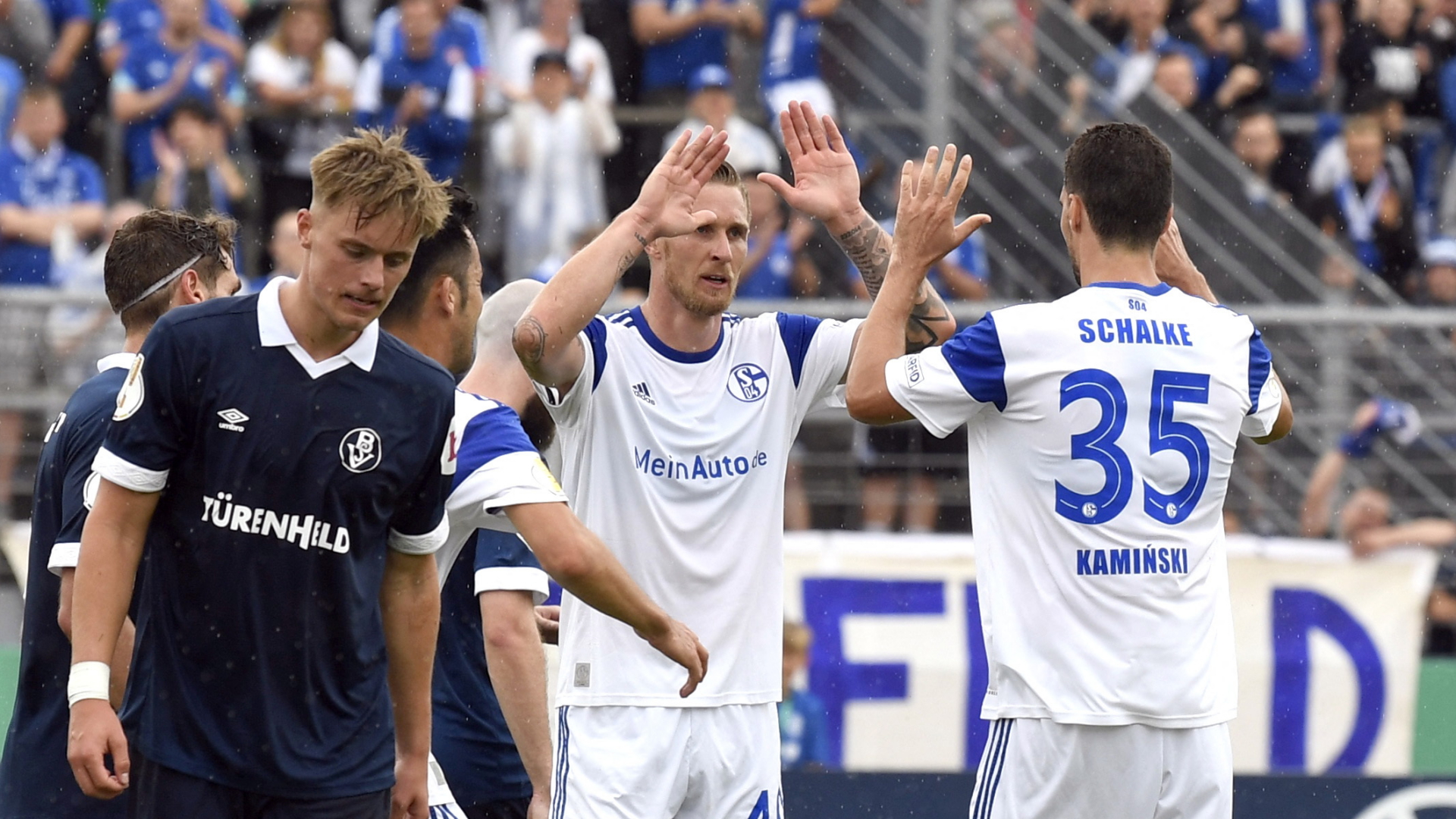 Marcin Kaminski und Sebastian Polter vom FC Schalke 04 klatschen nach dem 5:0 im DFB-Pokal gegen den Bremer SV ab. | REUTERS