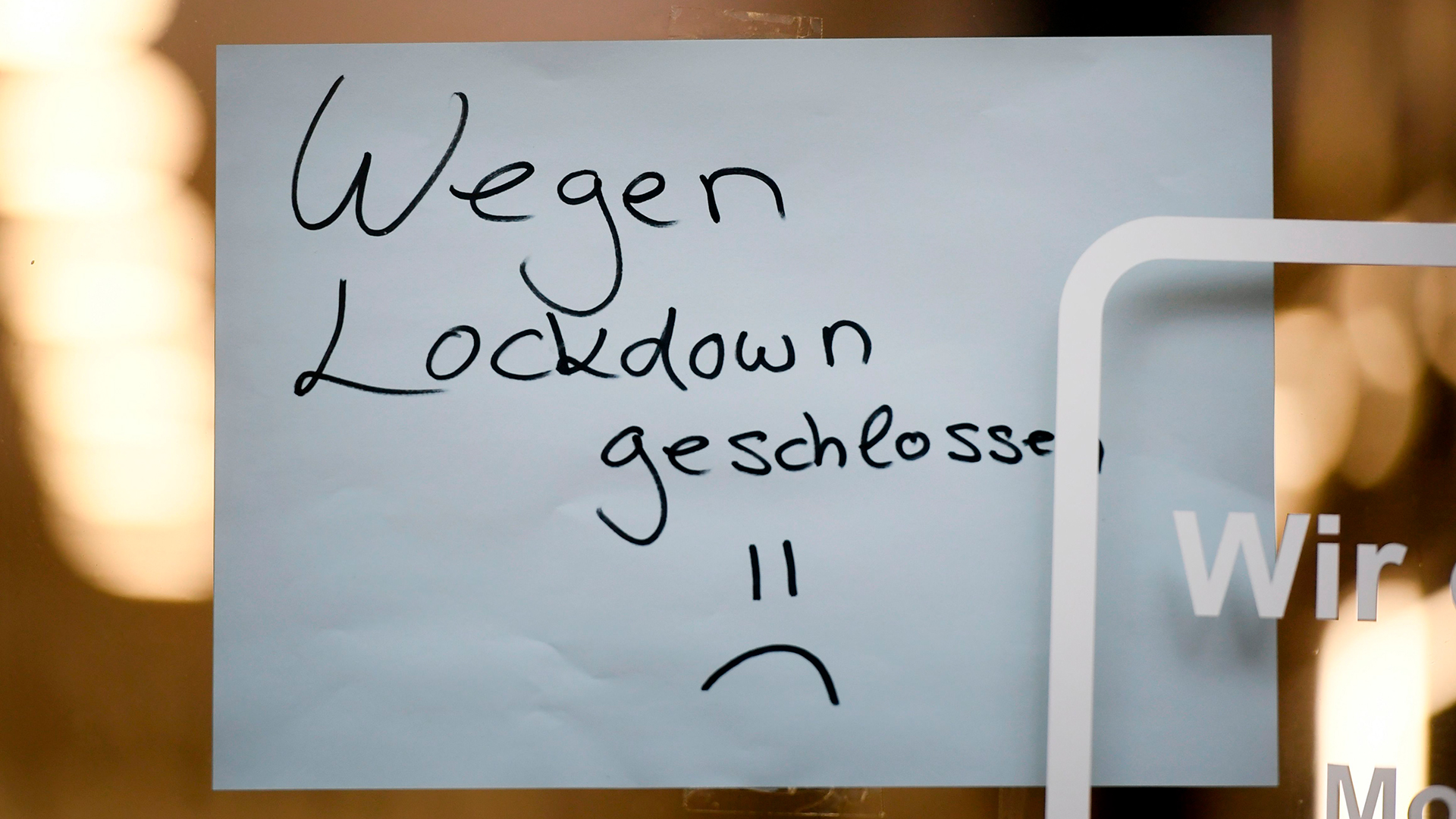 Ein Schild mit der Aufschrift "Wegen Lockdown geschlossen" hängt in einem Geschäft in Köln