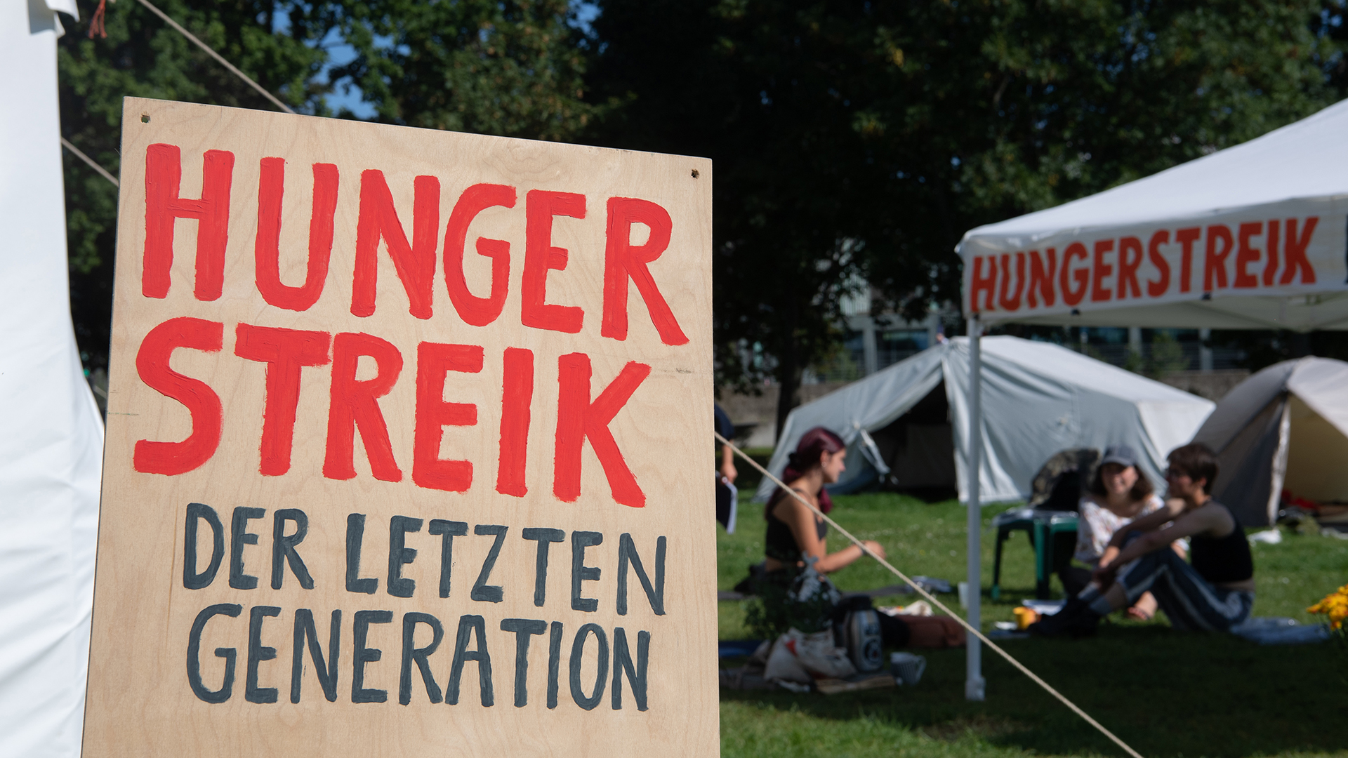"Hungerstreik" steht in Großbuchstaben auf einem Schild im Camp der Klimaaktivisten. | dpa