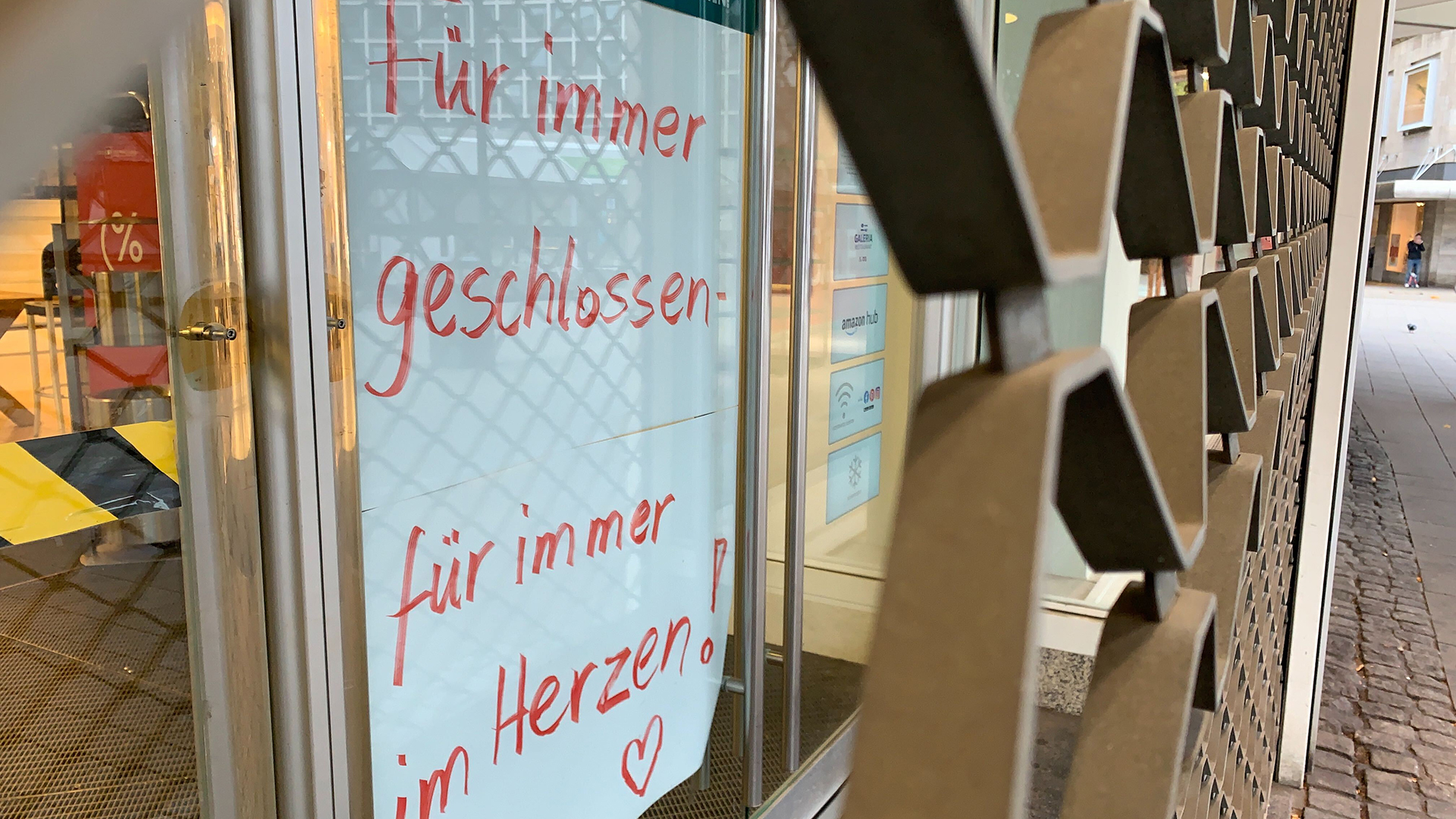 Ein Plakat mit der Aufschrift "Für immer geschlossen - für immer im Herzen" hängt in der geschlossenen Kaufhof Filiale in Essen | dpa