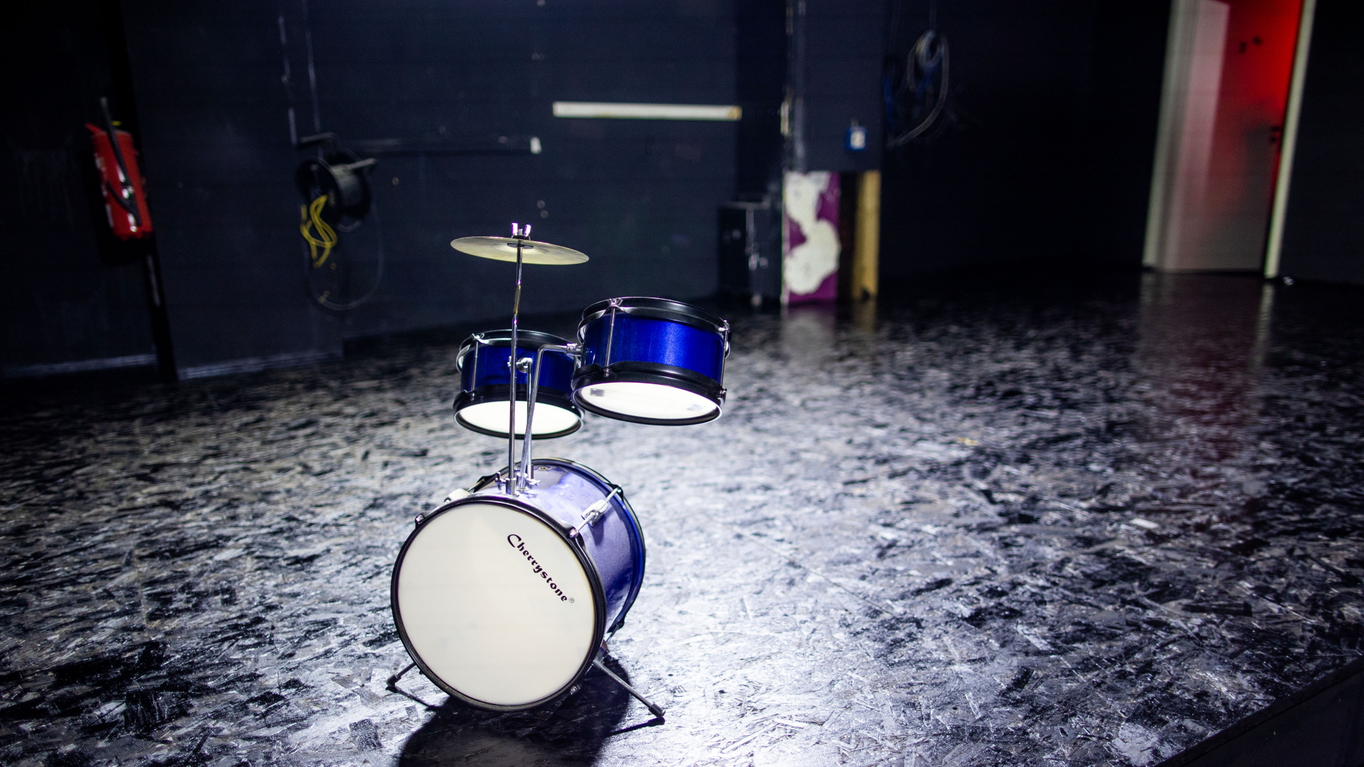Ein Deko-Schlagzeug steht auf der leeren Bühne in der Diskothek