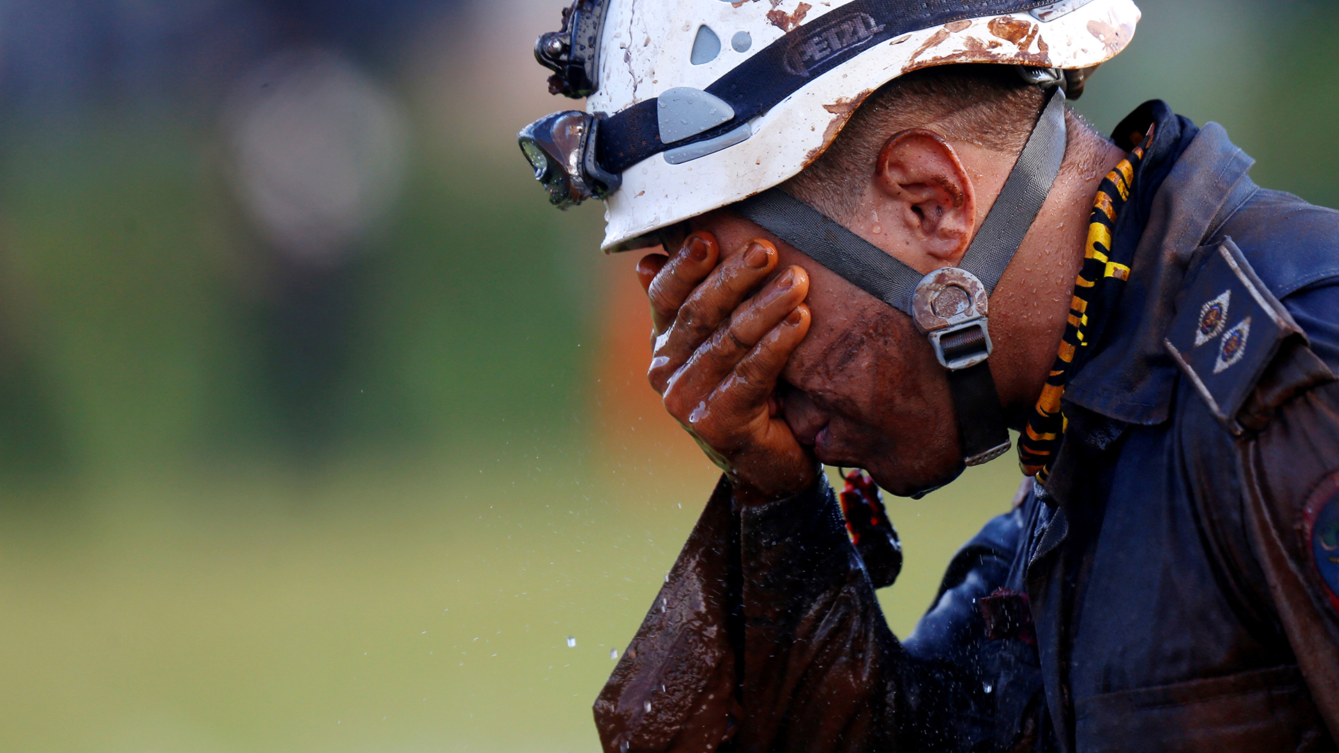 Ein Helfer vergräbt sein Gesicht in seiner Hand. | Bildquelle: REUTERS