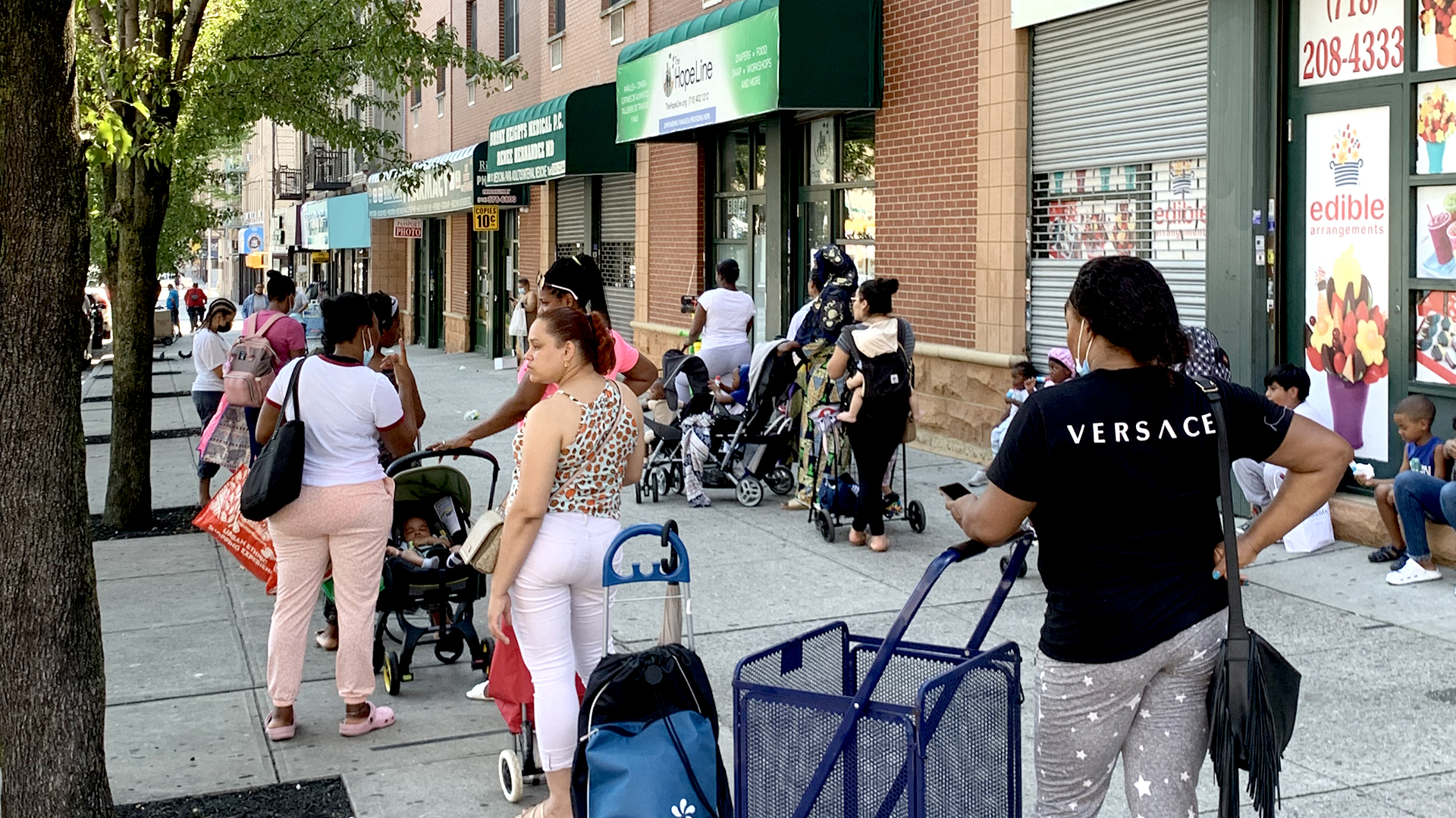 Menschen stehen in einer Schlange vor einer Tafel in New York City. | ARD-Studio New York
