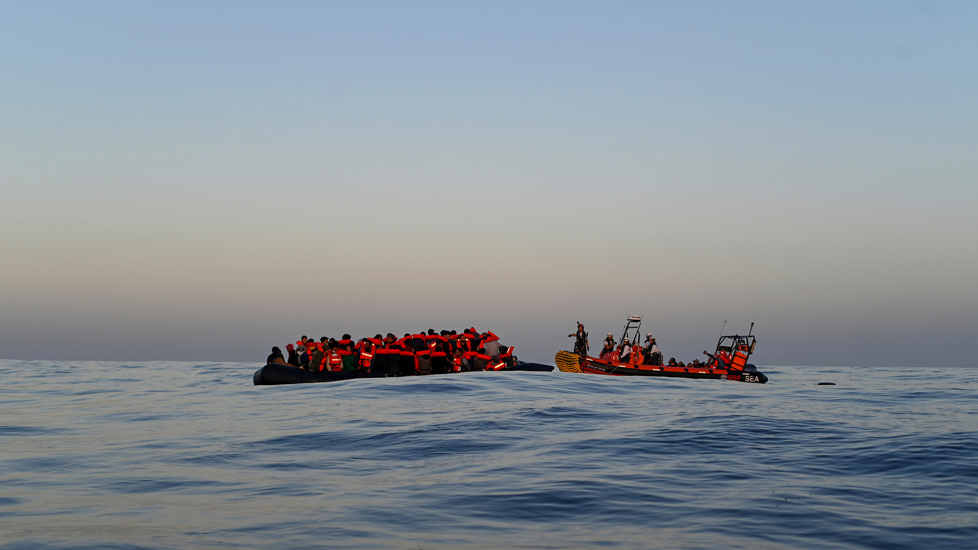 Ein Rettungsteam der humanitären Organisation Ärzte ohne Grenzen (MSF) nähert sich im Mittelmeer einem Schlauchboot mit 74 Migranten an Bord. | AP