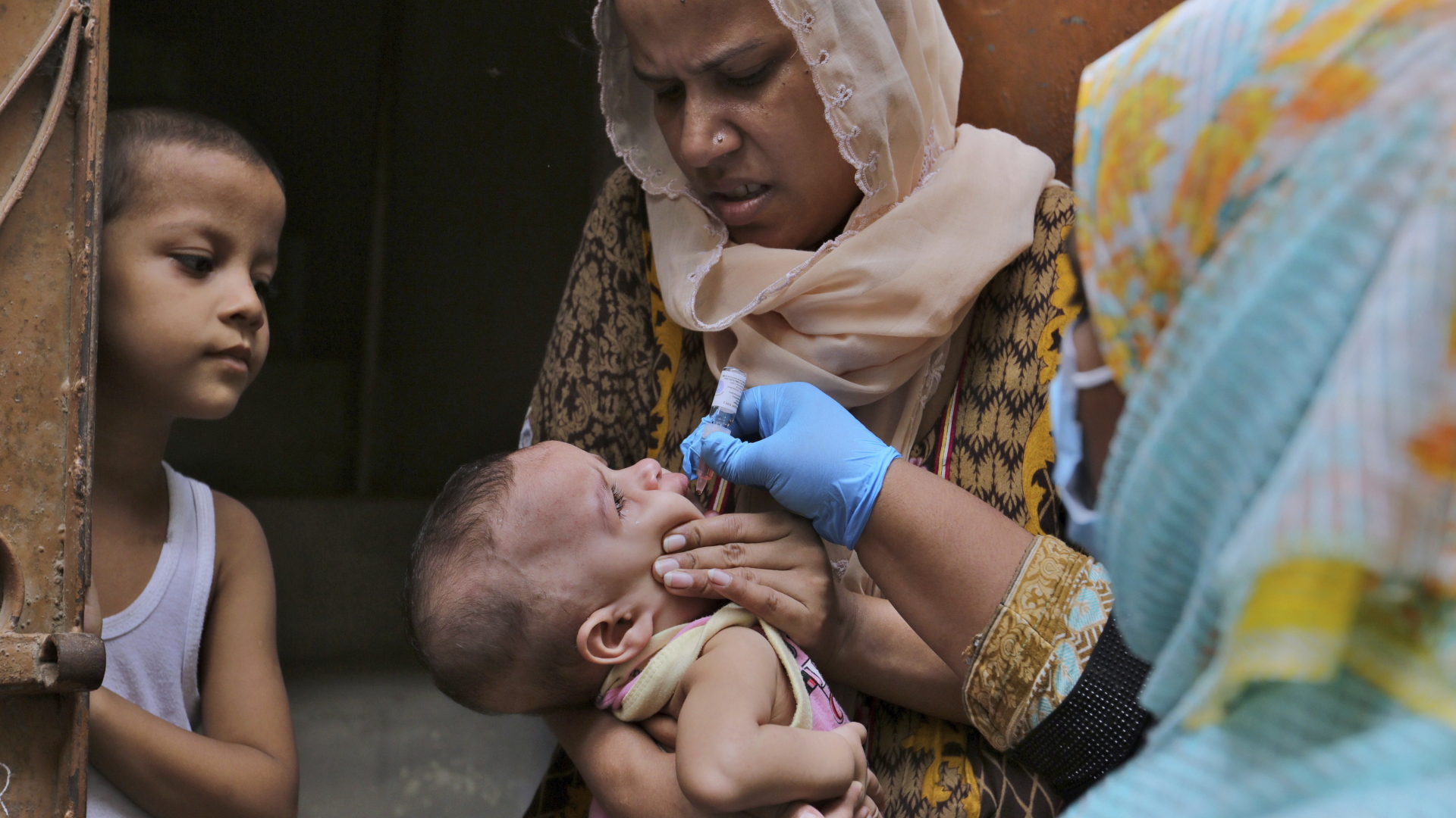 Eine Mitarbeiterin des Gesundheitswesens verabreicht einem Kind einen Polio-Impfstoff. | dpa