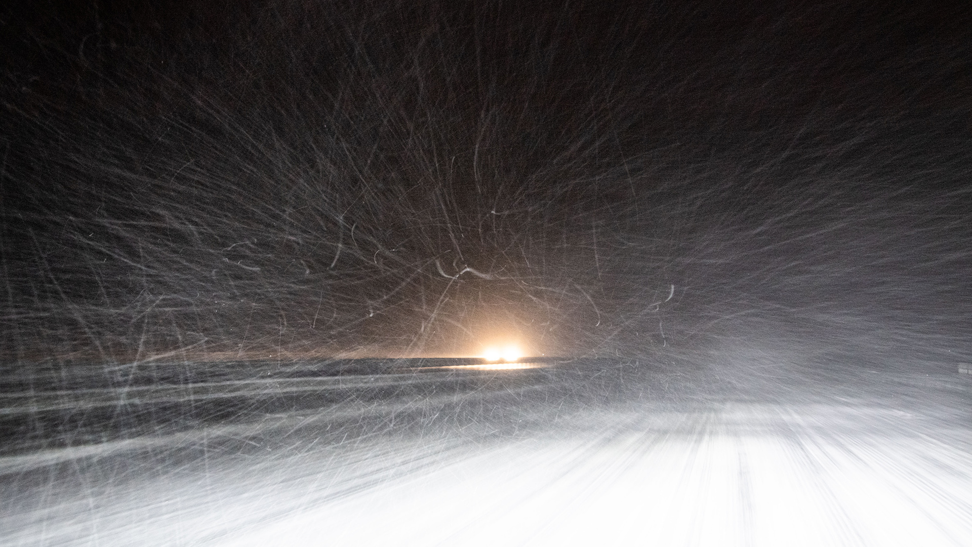 Nordrhein-Westfalen, Lage: Dichtes Schneetreiben auf einer Autobahn wird von den Scheinwerfern eines entgegenkommenden Autos angeleuchtet. | dpa
