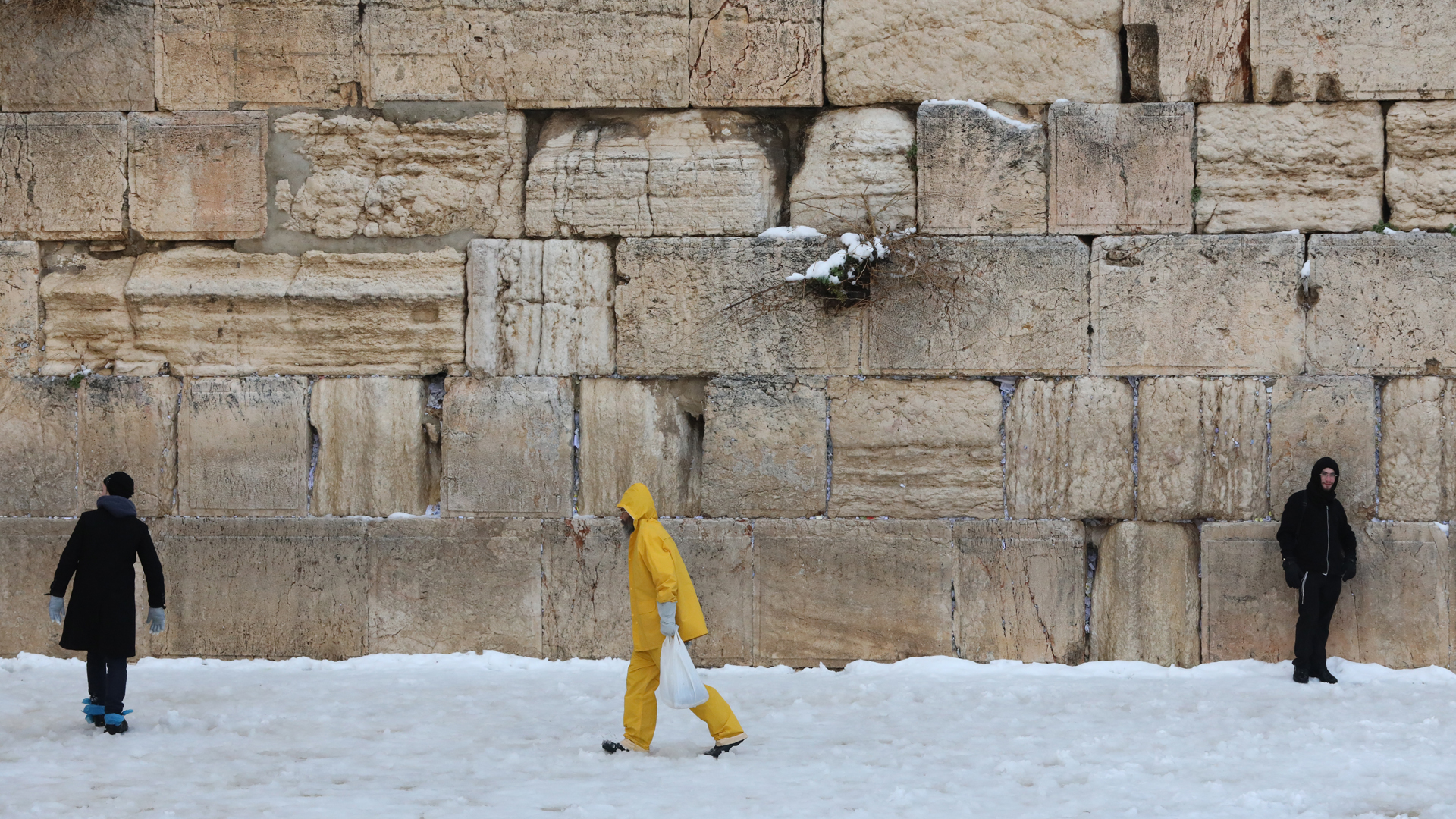 Menschen gehen nach einem Schneesturm an der Klagemauer in der Altstadt von Jerusalem vorbei. | EPA