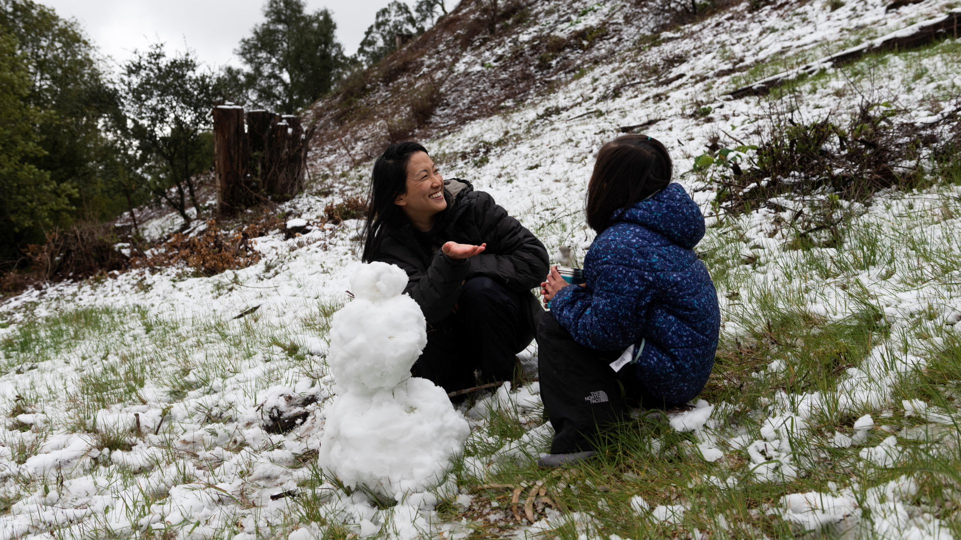 Eine Mutter und ihre Tochter bauen eine Schneemann aus dem Schnee, der in den Hügeln der Bay Area gefallen ist | REUTERS