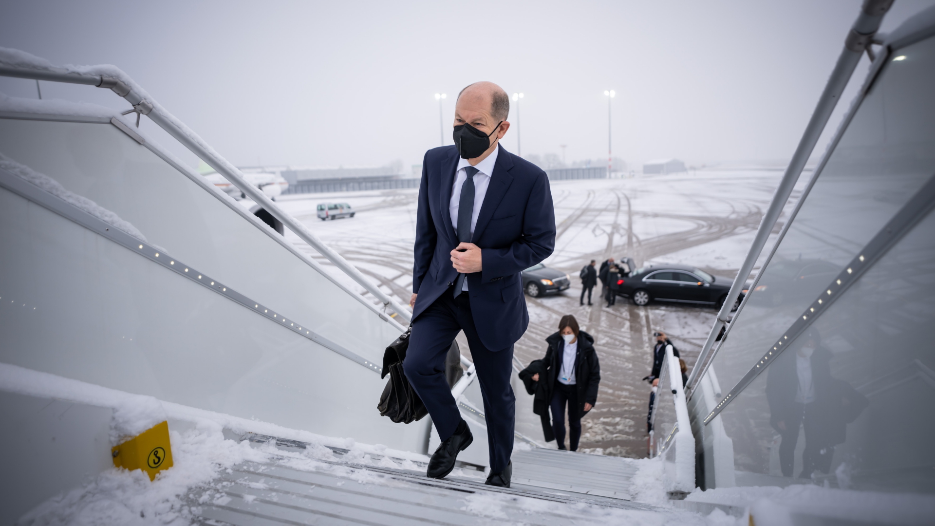 Scholz beim Betreten der Regierungsmaschine am verschneiten Berliner Flughafen | dpa