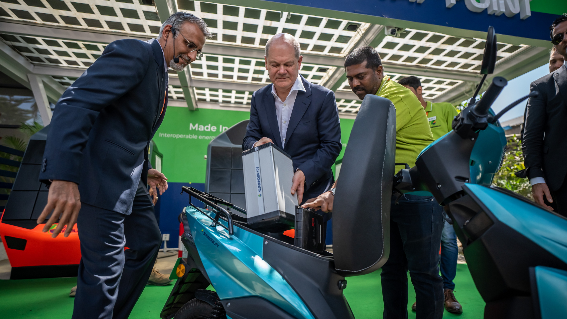 Olaf Scholz besichtigt das Unternehmen Sun Mobility zusammen mit dem Gründer Chetan Maini im indischen Silicon Valley Bengaluru und wechselt einen Akku an einem Roller. | dpa