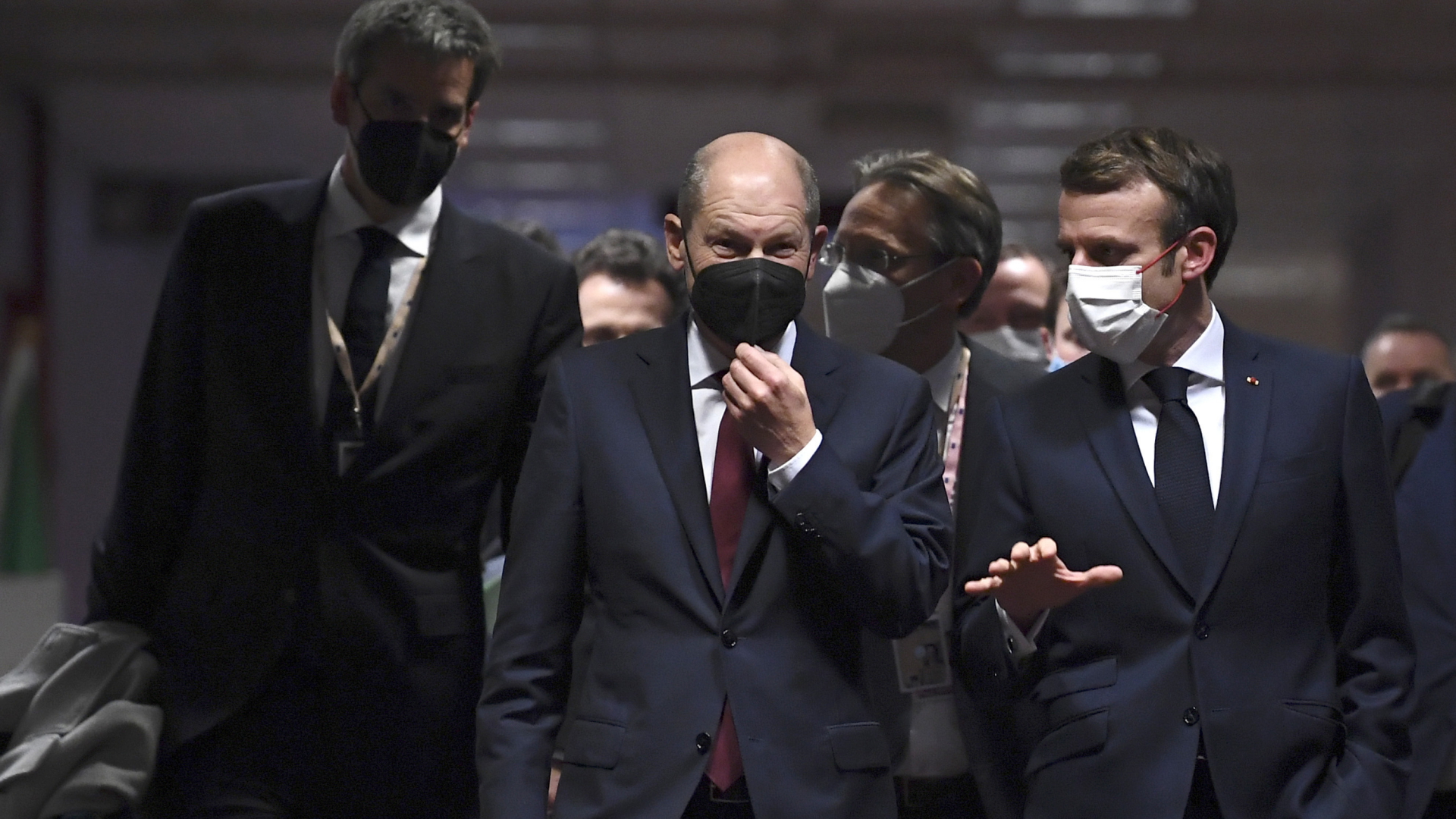 Bundeskanzler Olaf Scholz und Frankreichs Präsident Emmanuel Macron (rechts) gehen bei EU-Gipfel über einen Flur. | dpa