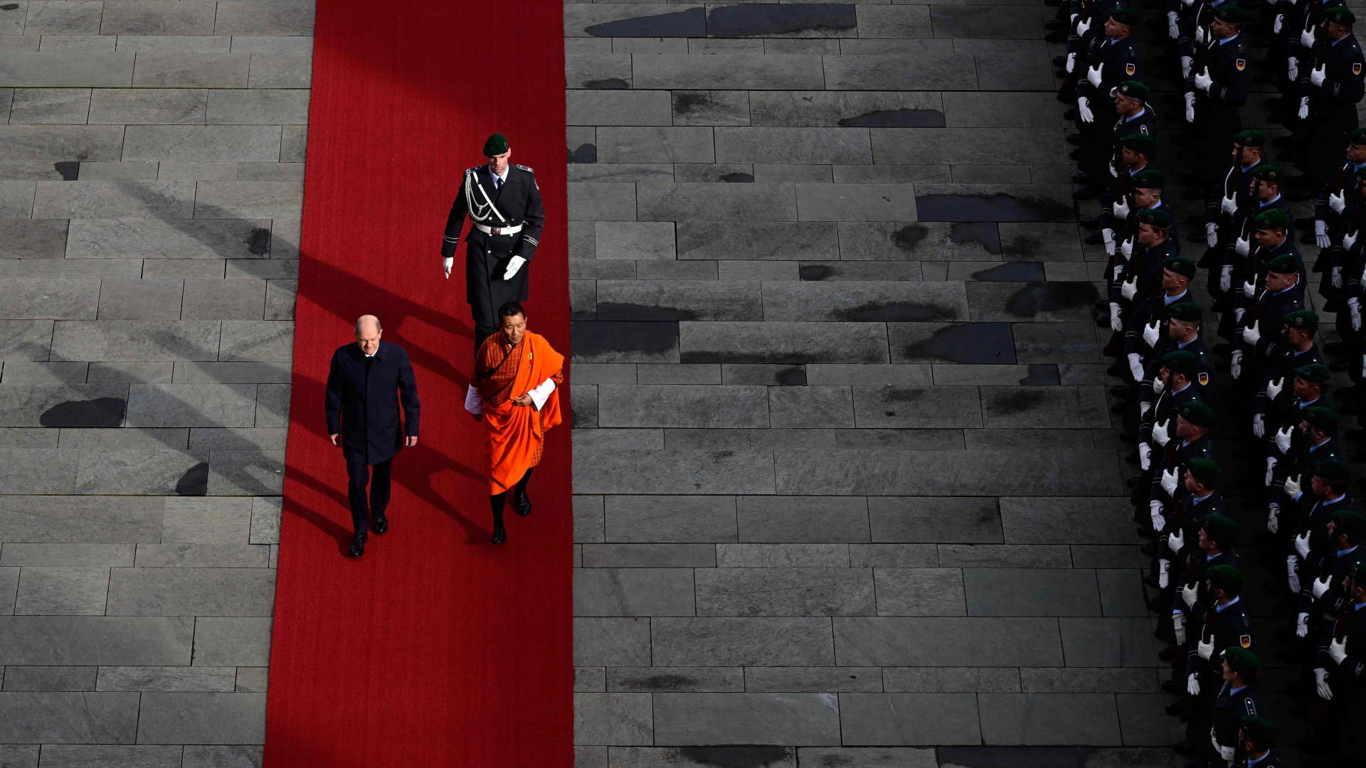 Olaf Scholz, Bundeskanzler, und Lotay Tshering, Bhutans Premierminister, laufen über den roten Teppich während einer Begrüßungszeremonie im Kanzleramt in Berlin. | AFP