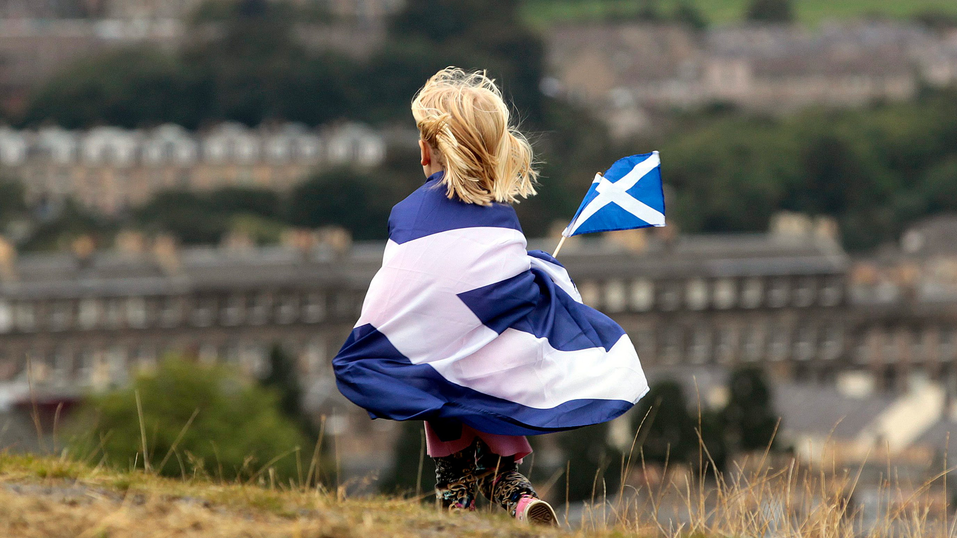 Ein Kind, das in eine schottische Flagge gehüllt ist. | picture alliance/dpa/epa