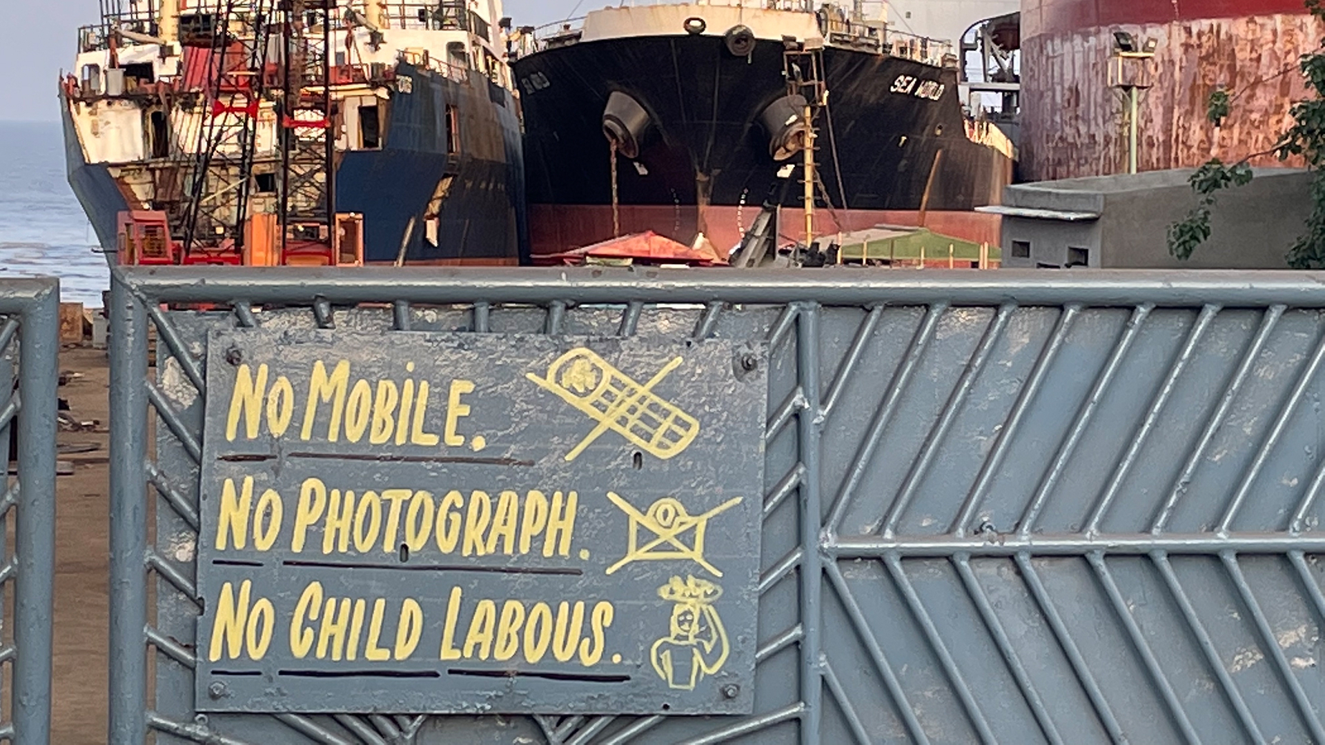 Aufschrift "Keine Handys, keine Fotos, keine Kinderarbeit" auf dem Schild einer indischen Werft. | NDR/ARD