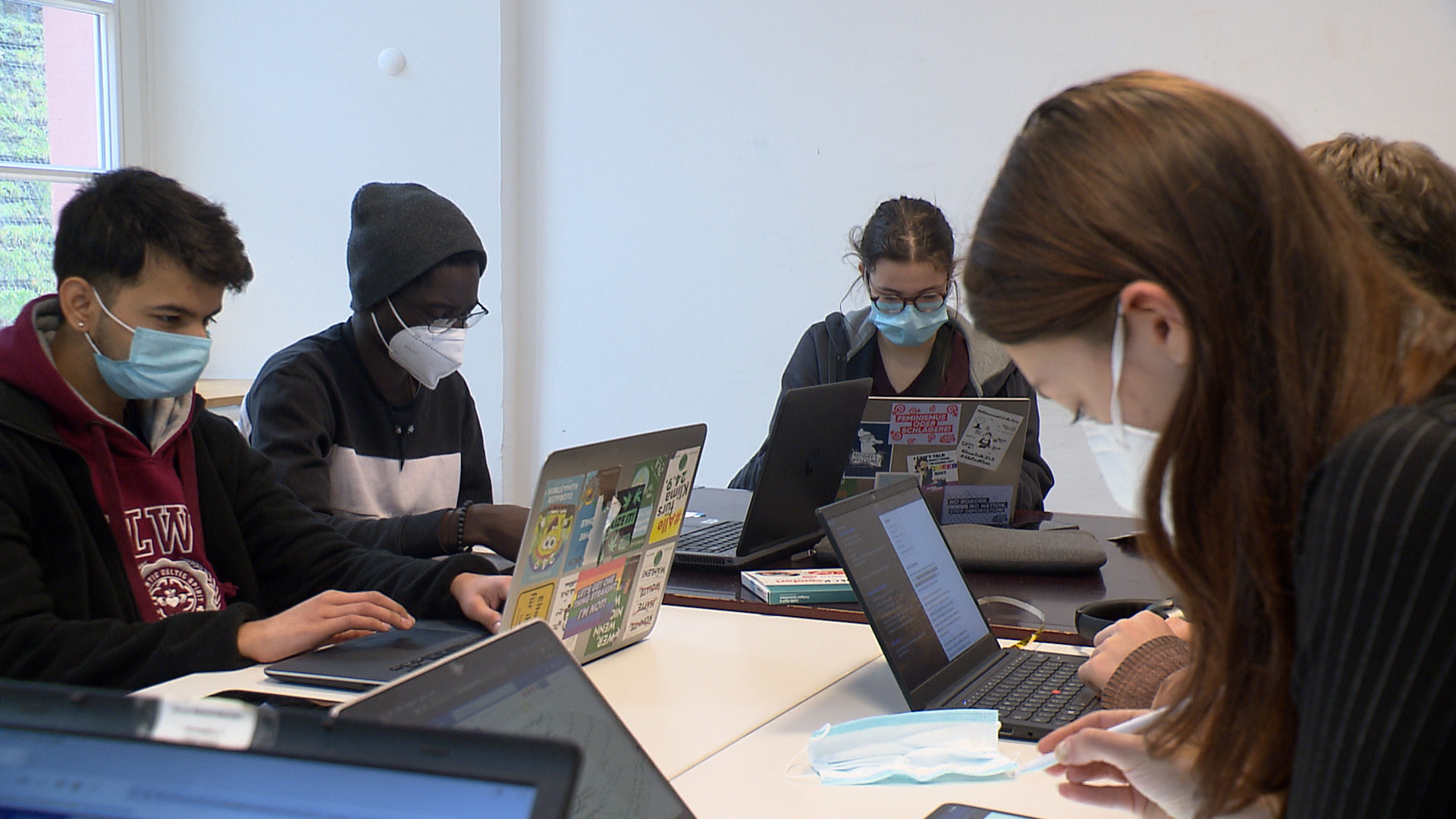 Eine Gruppe Schüler vom UWC-College Freiburg sitzen an Laptops.