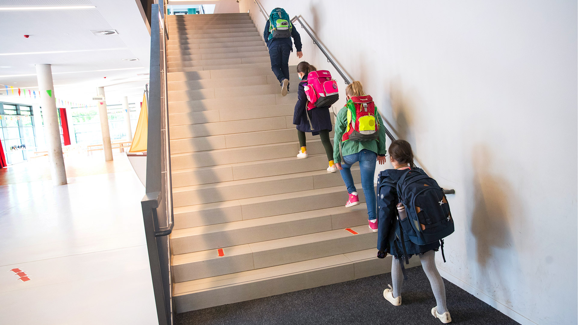 In Hamburg gehen Schülerinnen und Schüler einer 4. Klasse mit Abstand auf einer Treppe zu ihren Klassenräumen in der Goldbeck-Schule.  | dpa