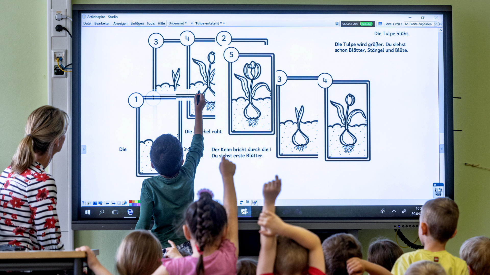 Grundschüler arbeiten an einer interaktiven digitalen Schultafel.
