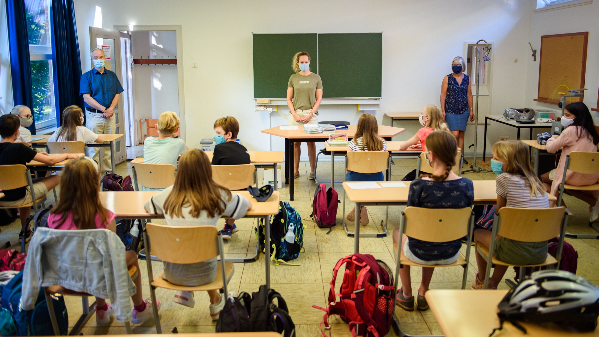Kinder sitzen in einem Klassenzimmer vor Lehrern