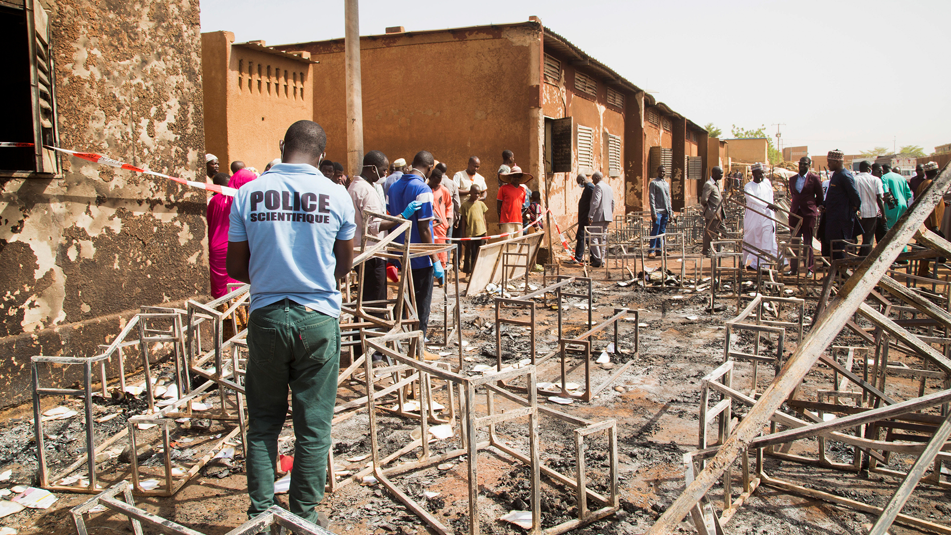 Ein Polizist aus Niger inspiziert die Überreste des abgebrannten Schulgebäudes in Niamey. | REUTERS