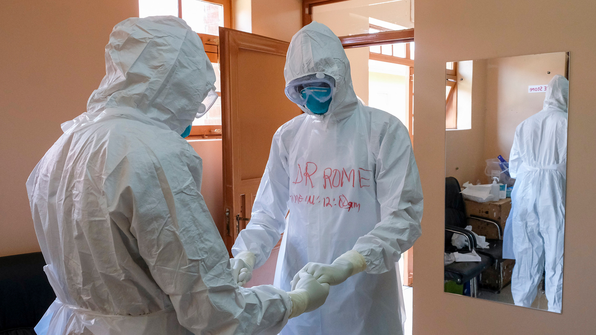Ärzte mit Schutzausrüstung beten gemeinsam, bevor sie einen Patienten besuchen, der mit einem Ebola-Opfer in Kontakt war, im Referral Hospital in Entebbe, Uganda. | AP