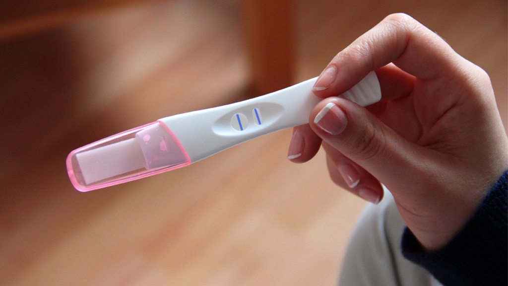 Eine Frau hält einen positiven Schwangerschaftstest in der Hand. | picture alliance / dpa Themendie