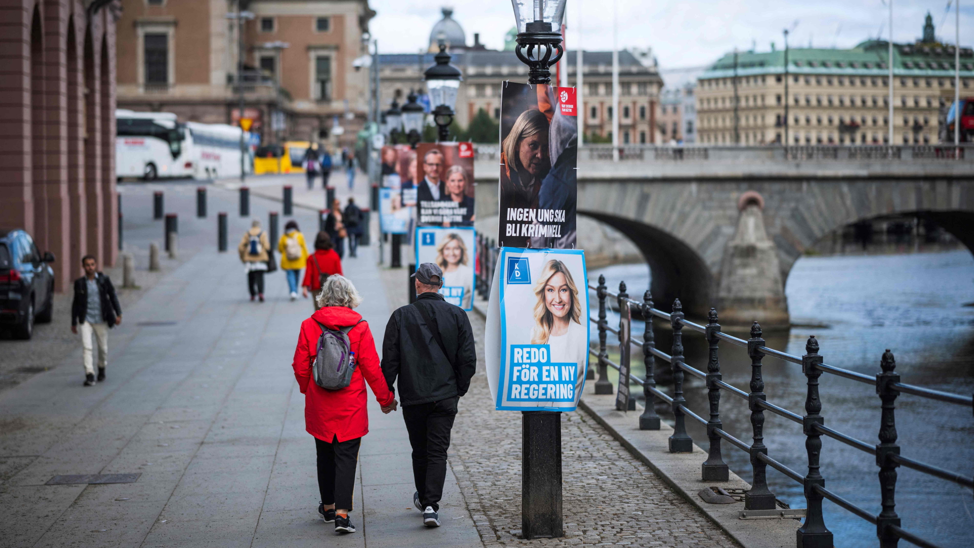 Passanten laufen an einer Laterne in Stockholm vorbei. | AFP