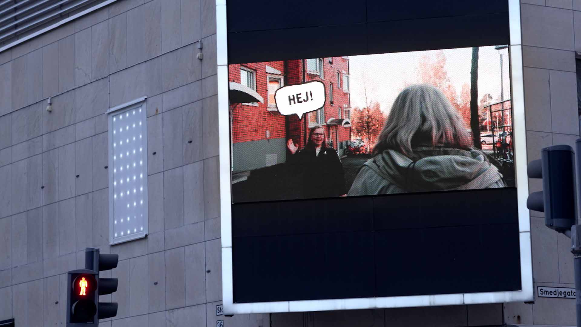 In Lulea (Schweden) wirbt ein Video auf einer öffentlichen Videowand dafür, sich zu zu grüßen.