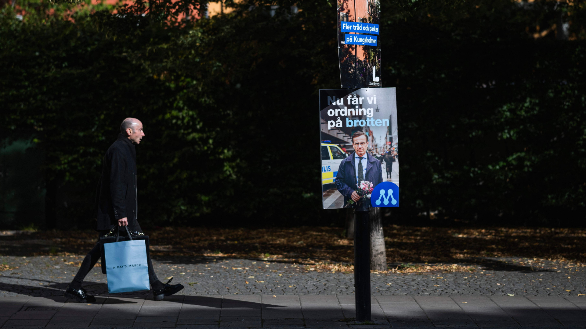 Ein Mann läuft an einem Wahlplakat in Stockholm vorbei, auf dem der konservative Spitzenkandidat Ulf Kristersson für sich wirbt. | AFP