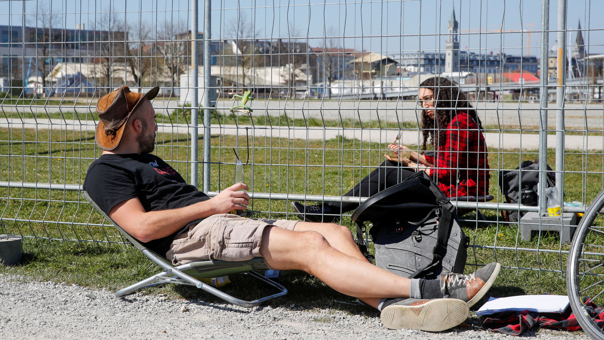 Ein Mann und eine Frau sprechen während der Corona-bedingten Abschottung zwischen Deutschland und der Schweiz an der Grenze durch ein Gitter miteinander. | REUTERS
