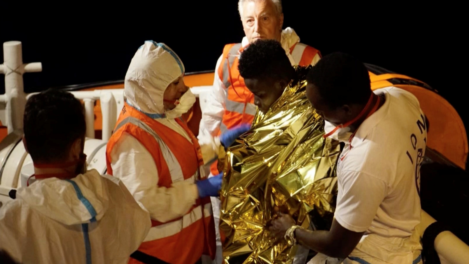 Ein jugendlicher Migrant wird in eine Thermodecke gehüllt von der "Sea-Watch 3" gebracht. | REUTERS