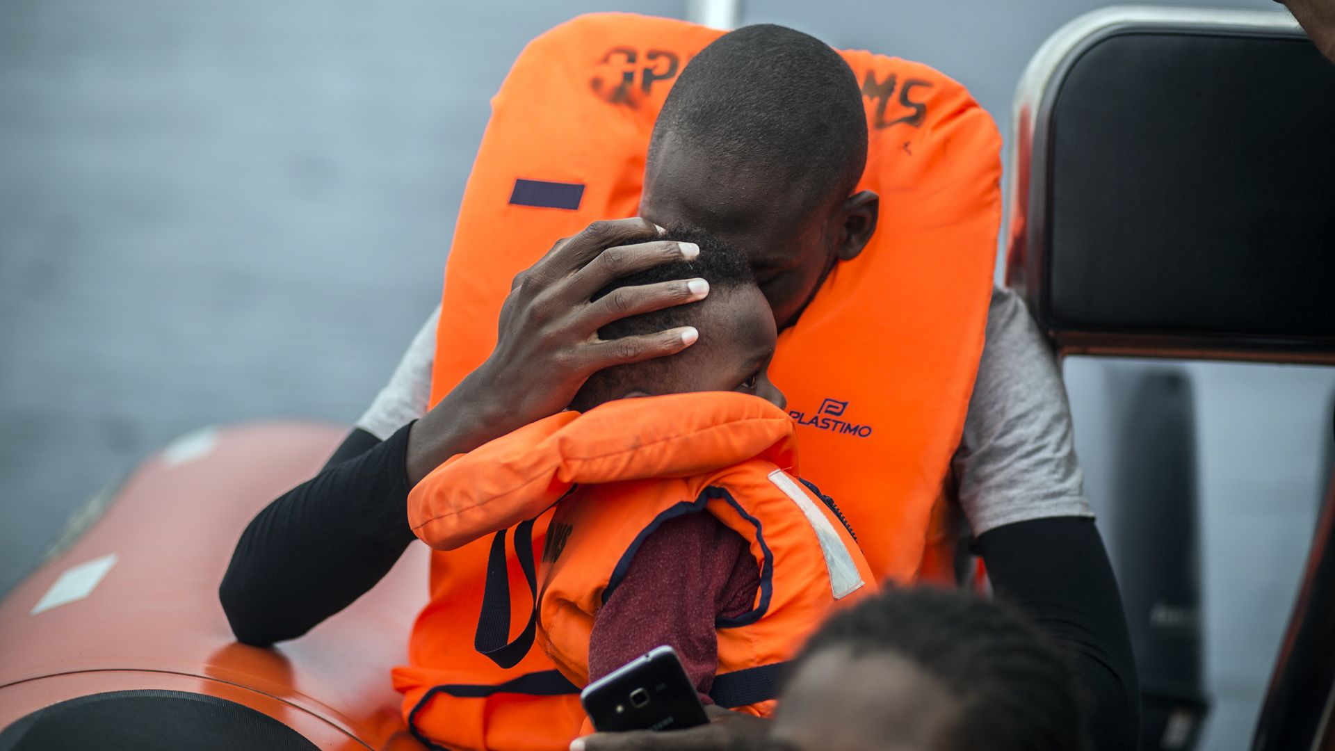 Ein Mann hält seinen Sohn im Arm, nachdem er aus dem Mittelmeer gerettet wurde. Die Seenotrettung übernehmen großteils private Hilfsinitiativen. | dpa