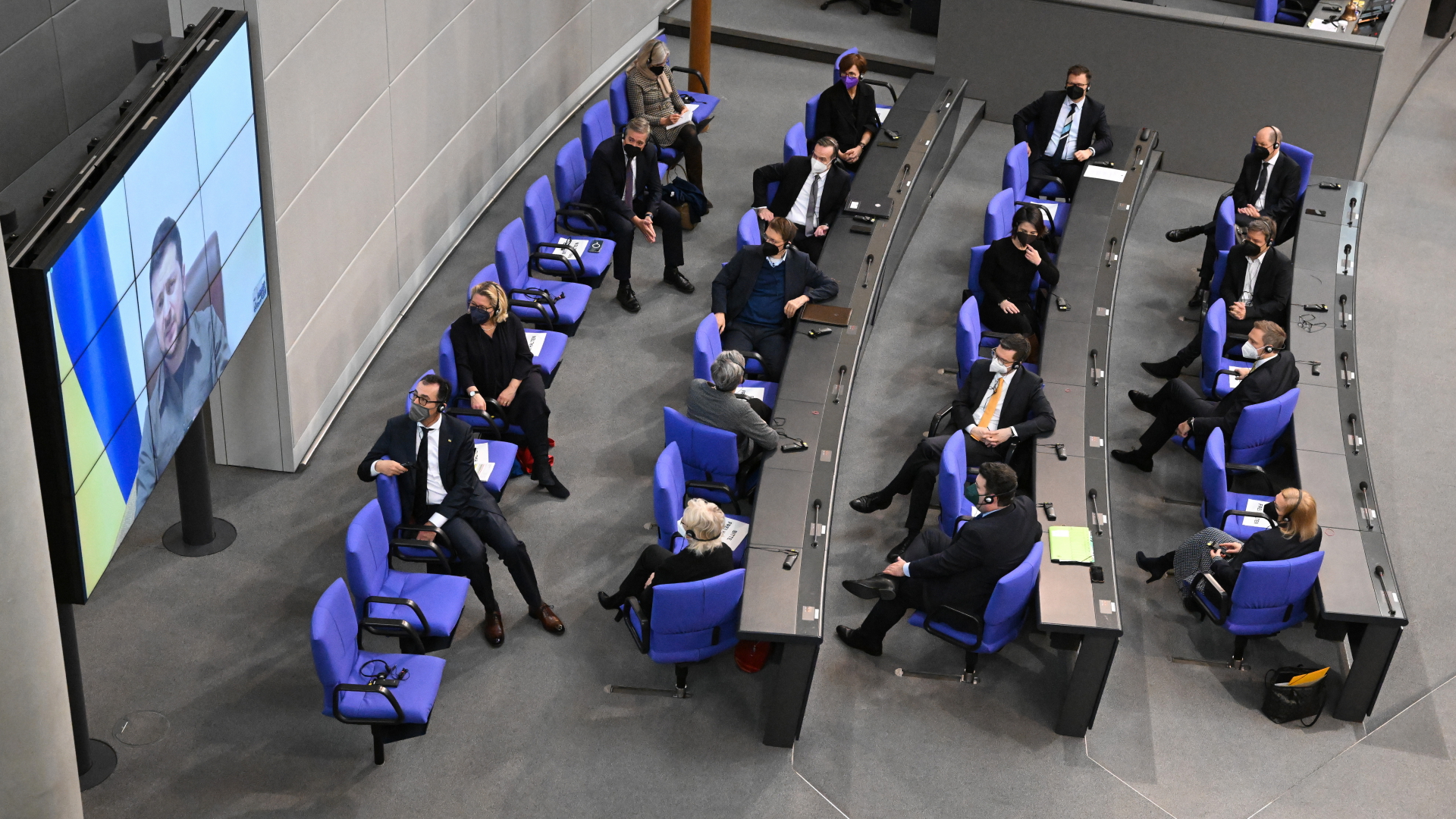 Der ukrainische Präsident Wolodymyr Selenskyj spricht auf einer Videoleinwand im Bundestag und die Bundesregierung hört zu. | dpa