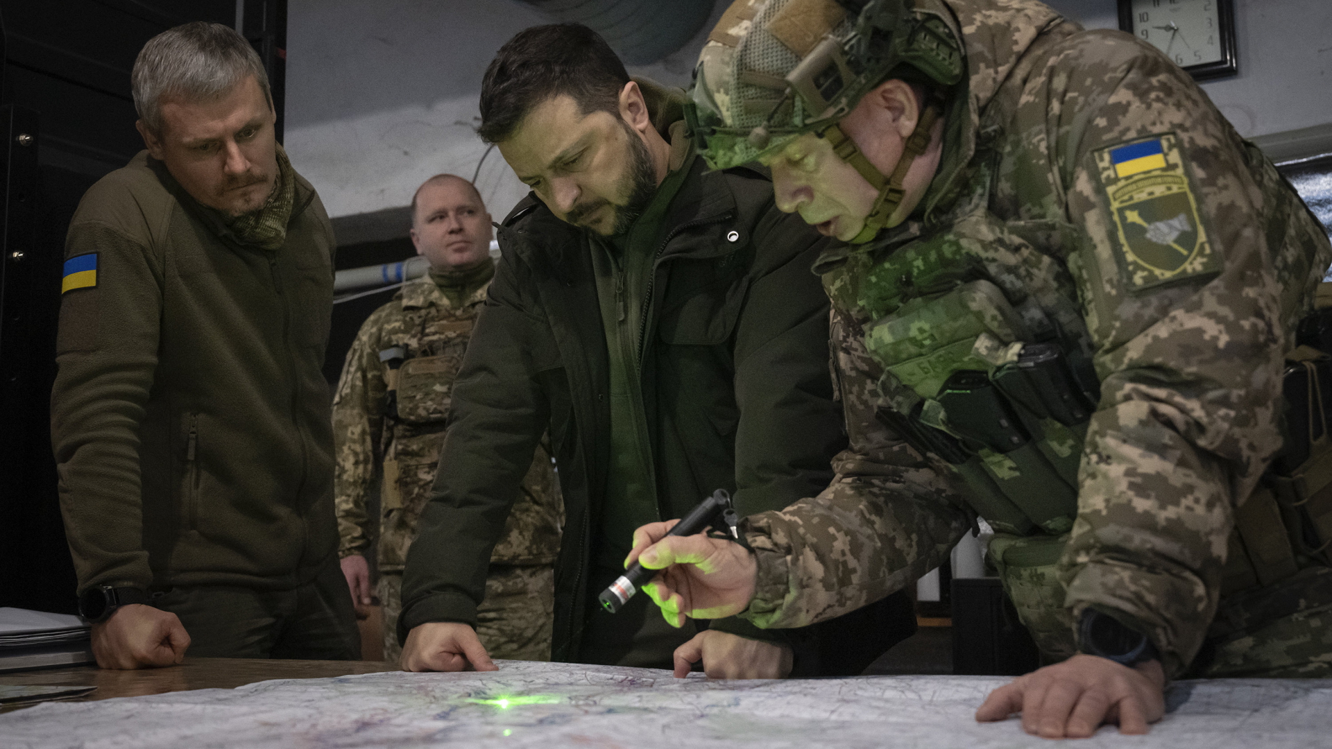 Der ukrainische Präsident Wolodymyr Selenskyj beugt sich mit Militärs bei Kupjansk über eine Karte.