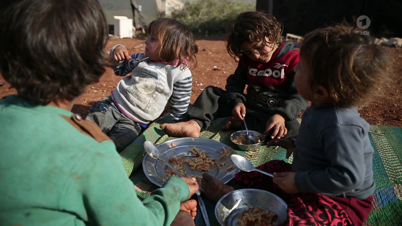 Kinder essen gemeinsam von einem Teller.