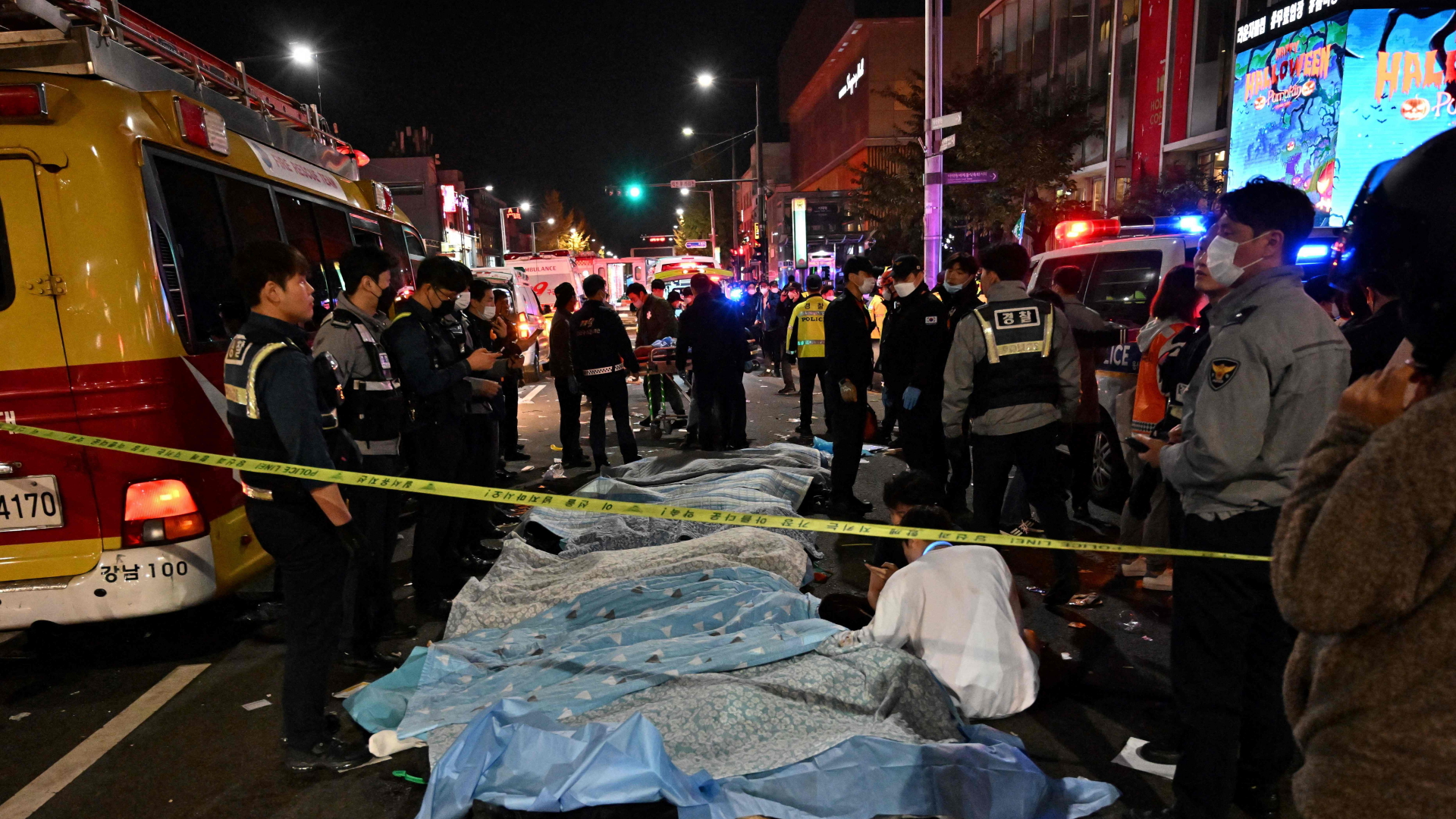 Opfer des Gedränges in Seoul liegen zugedeckt auf der Straße. | AFP